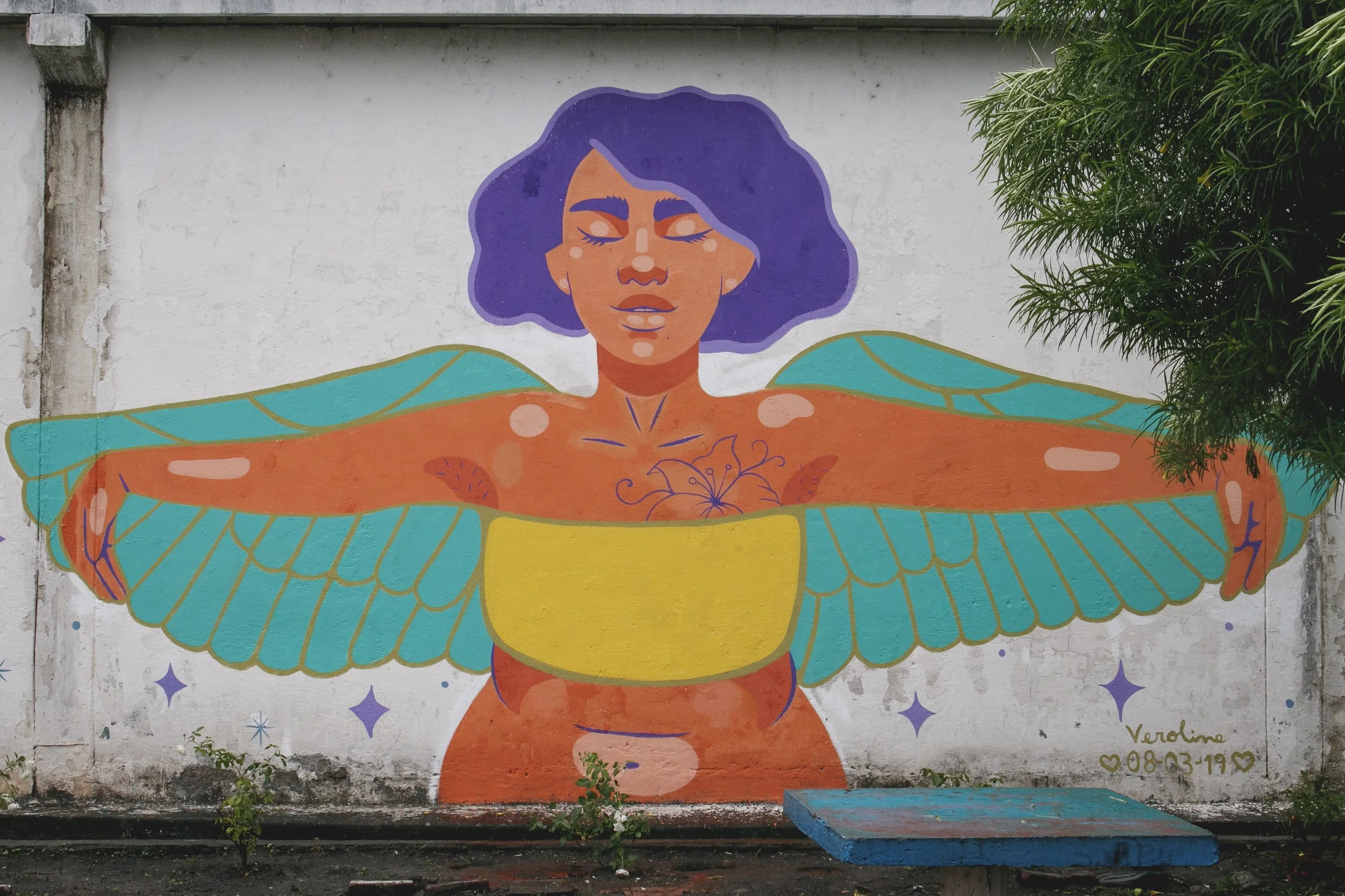 Hay una mujer con alas esperando en el muro