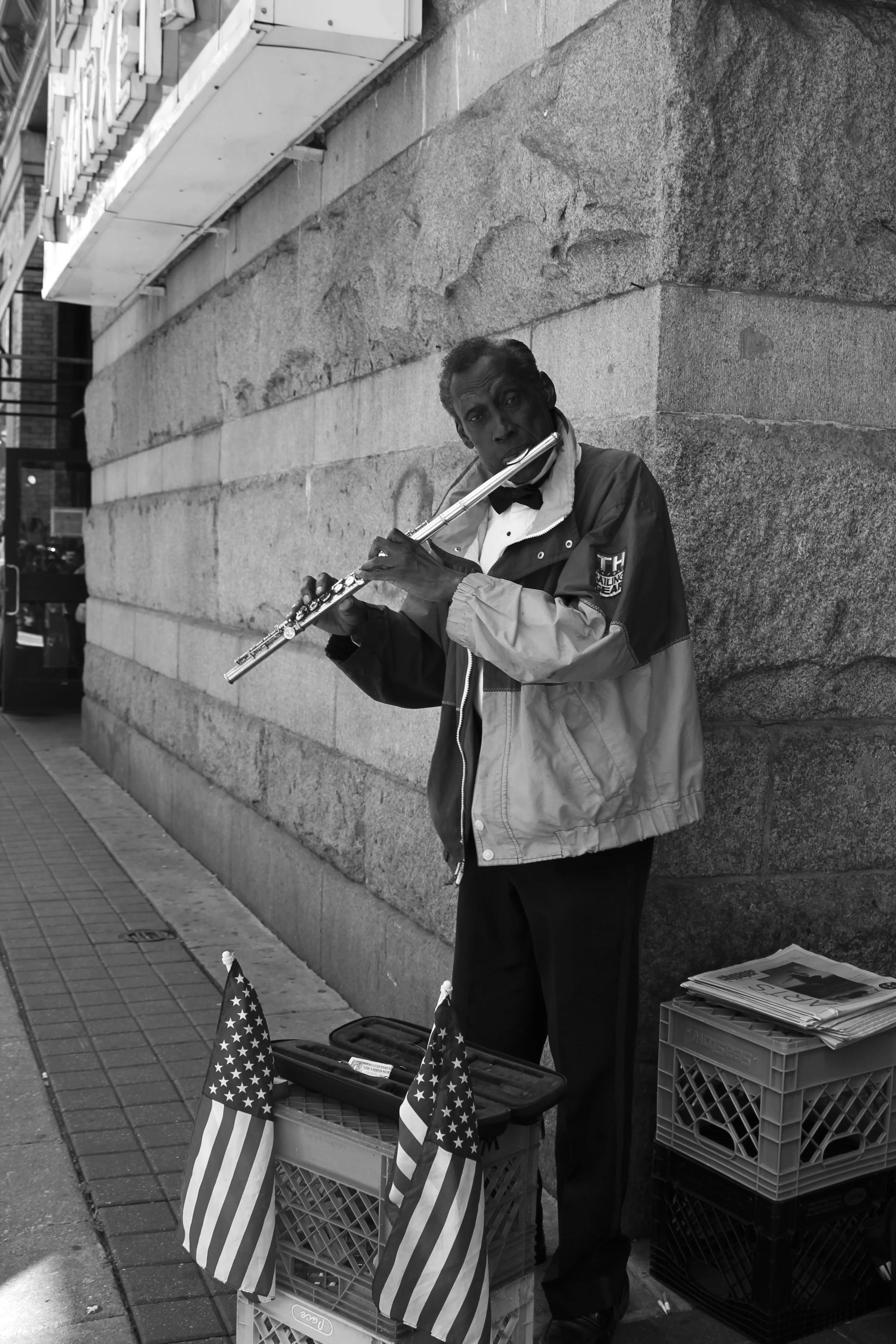 man plays flute on street in front of Reading Terminal Market