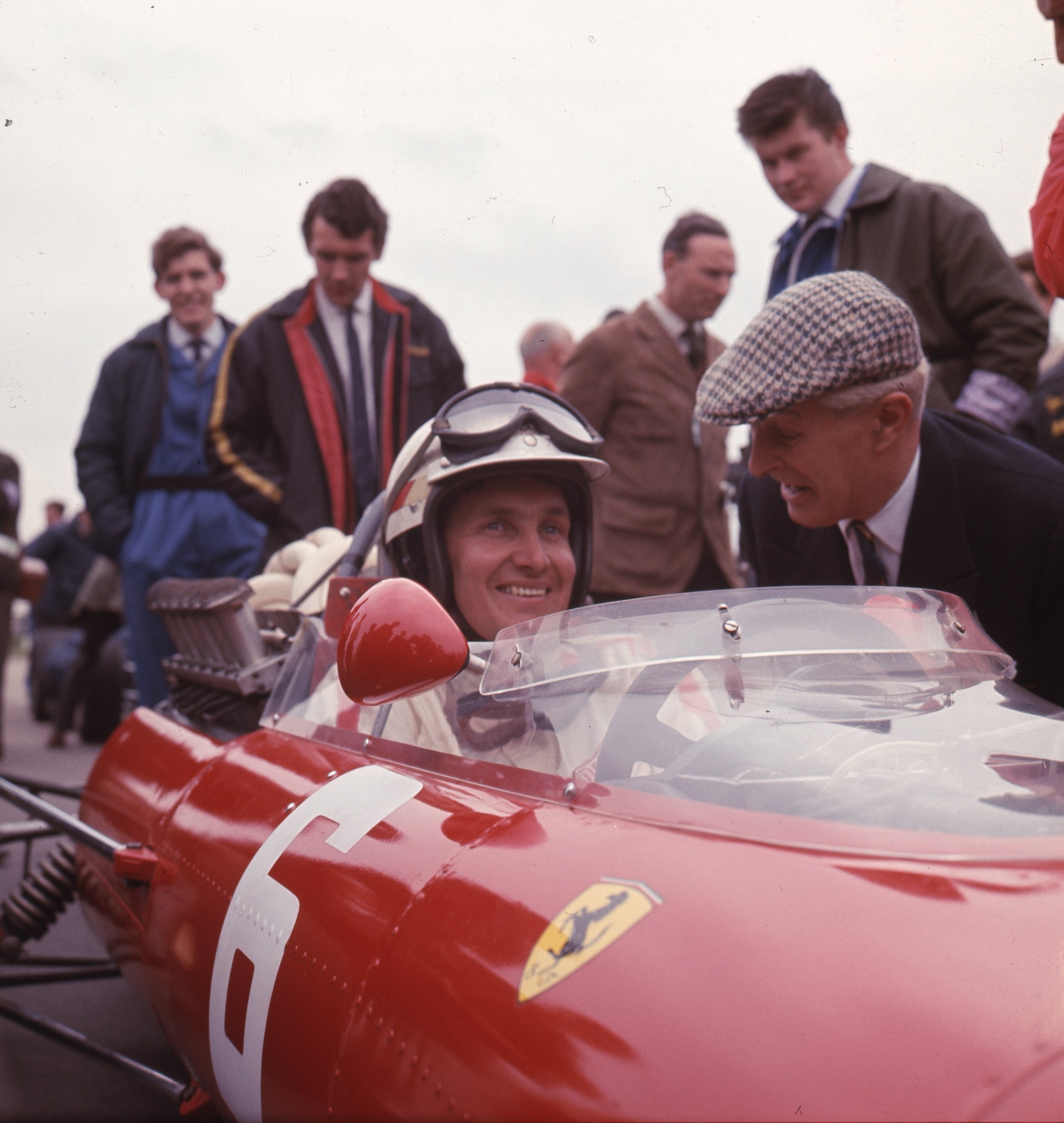I aspired to starting grids.. Guild of Motoring Writers chairman 1948 Tommy Wisdom talks to Ferrari engineer-driver Mike Parkes. Picture Eric Dymock