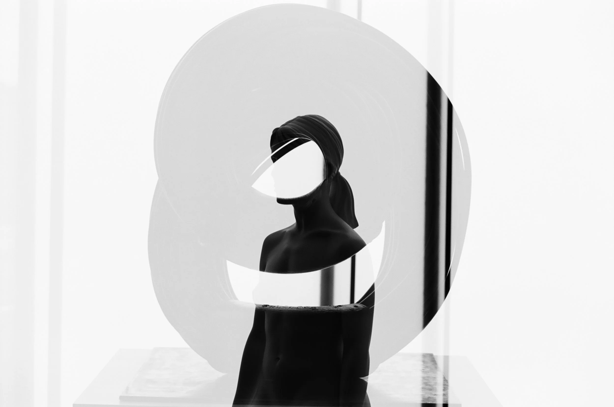 Black and white double exposure photo of two sculptures overlapping