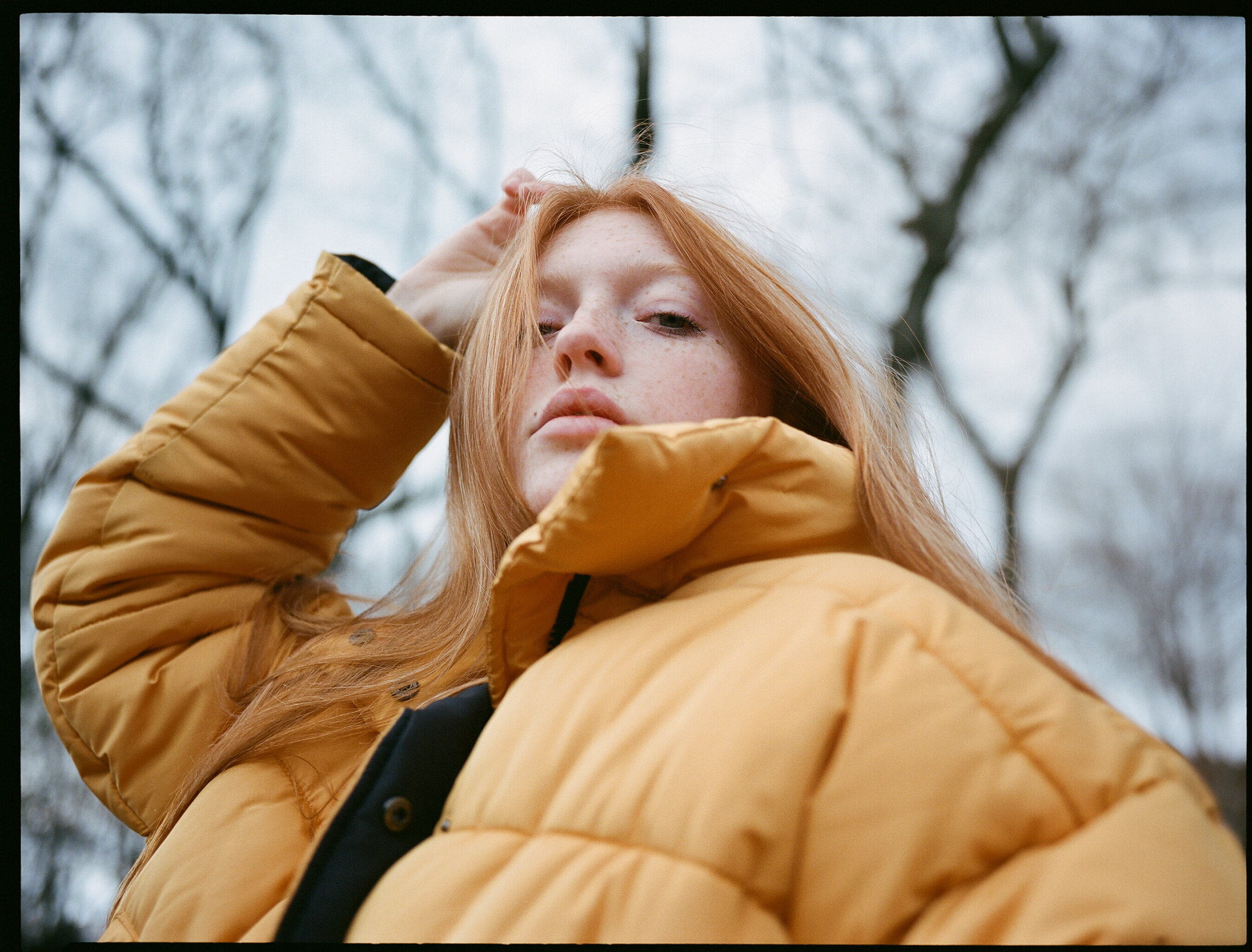 Redhead model Lili Ruger wearing a yellow puffy jacket in Central Park
