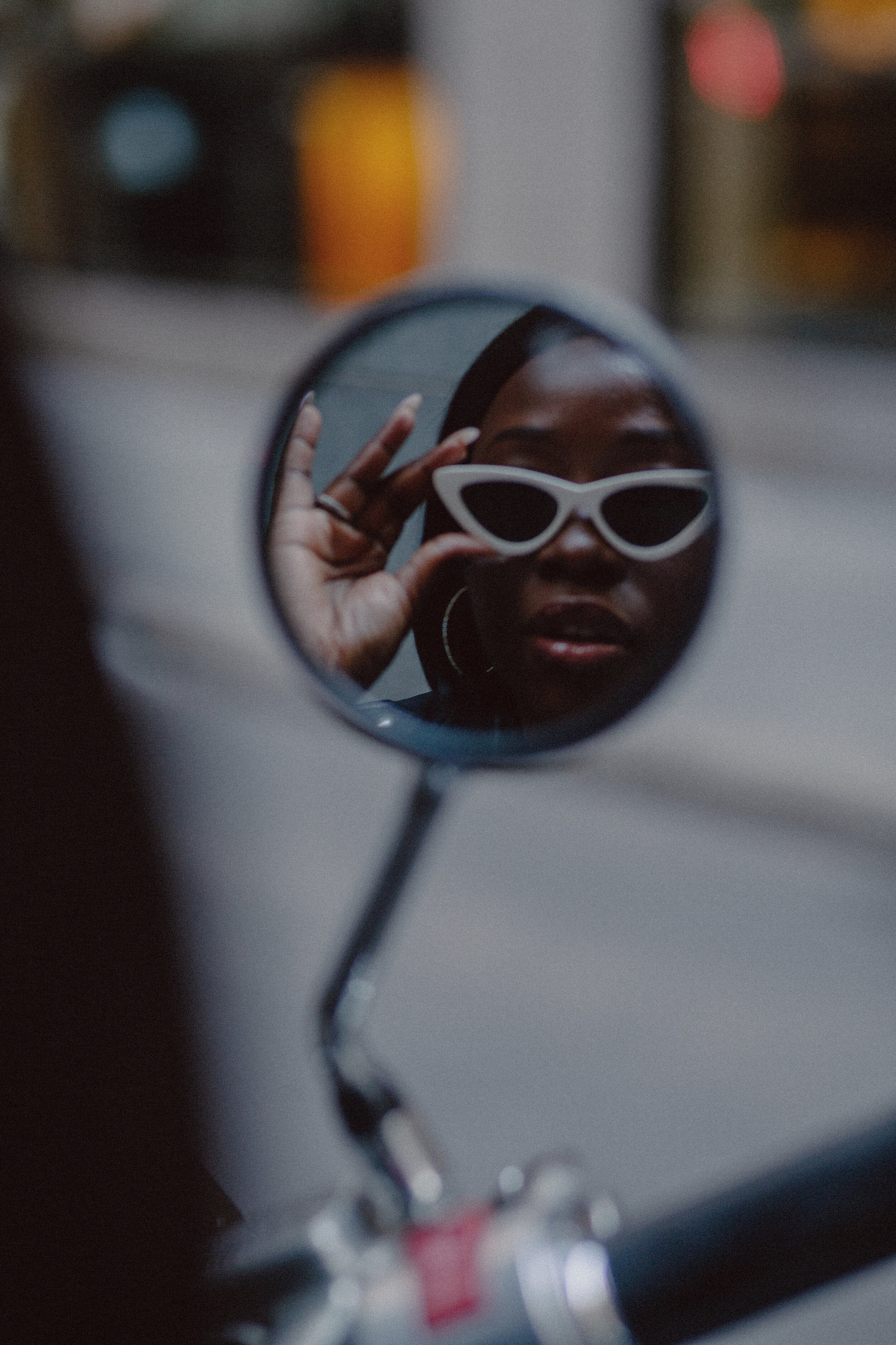 Artistic portrait of Moyo Ayodele reflection in a motorcycle mirror