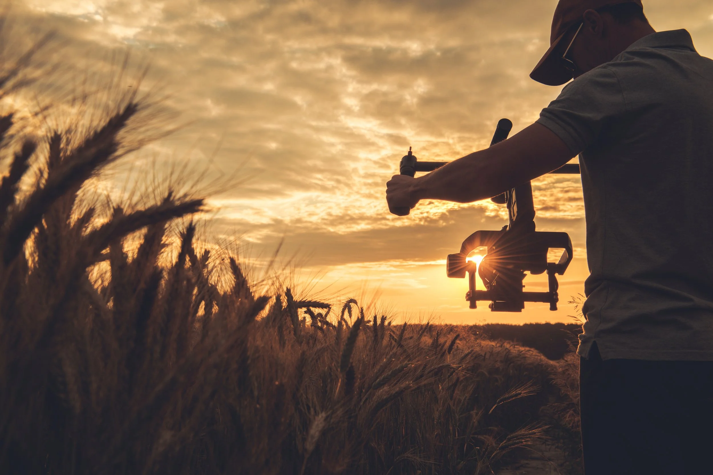 Video Camera Operator with Gimbal Stabilization Taking Scenic Sunset Shot
