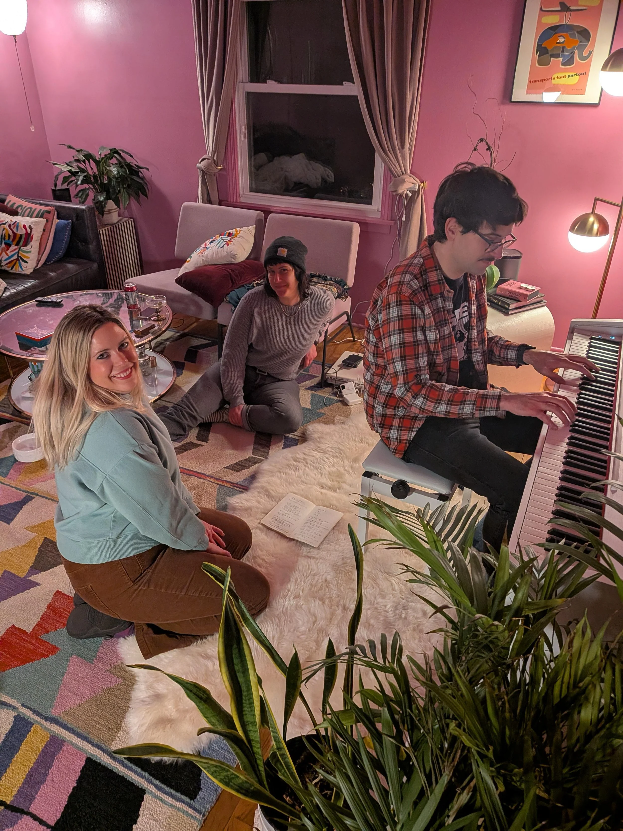Katie Bolin, Sarah Morrison, and Nigel Carleton of the Minneapolis electropop band DENNIS working on their new album coming in 2026