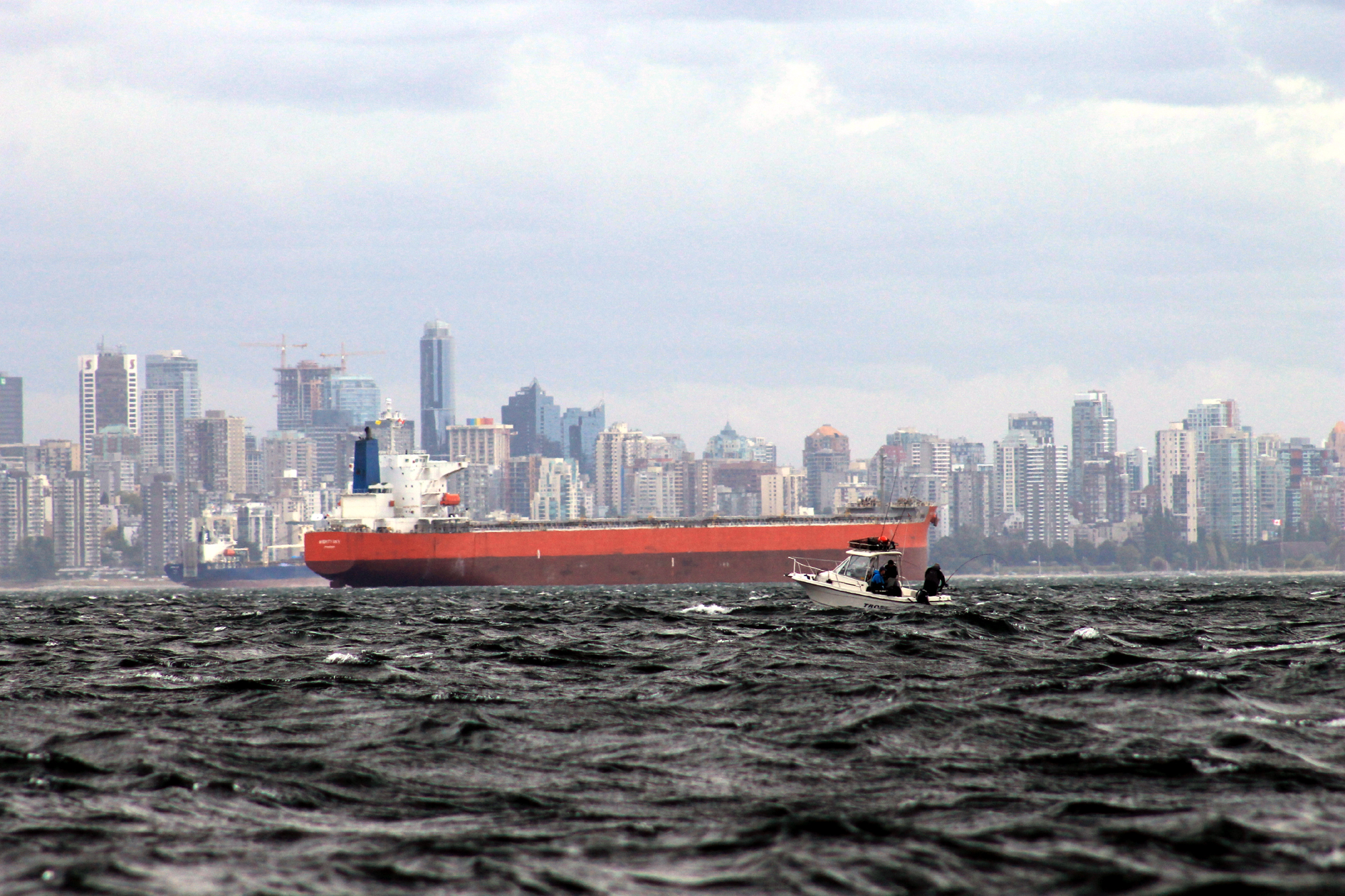 Fishing boat with freighter in Vancouver harbor. Photo by Todd Martin .