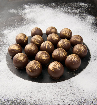 Photo of gold-dusted chocolates for Gold Refiners blog post about what you need to know about eating gold. Credit: Madiz/iStock.