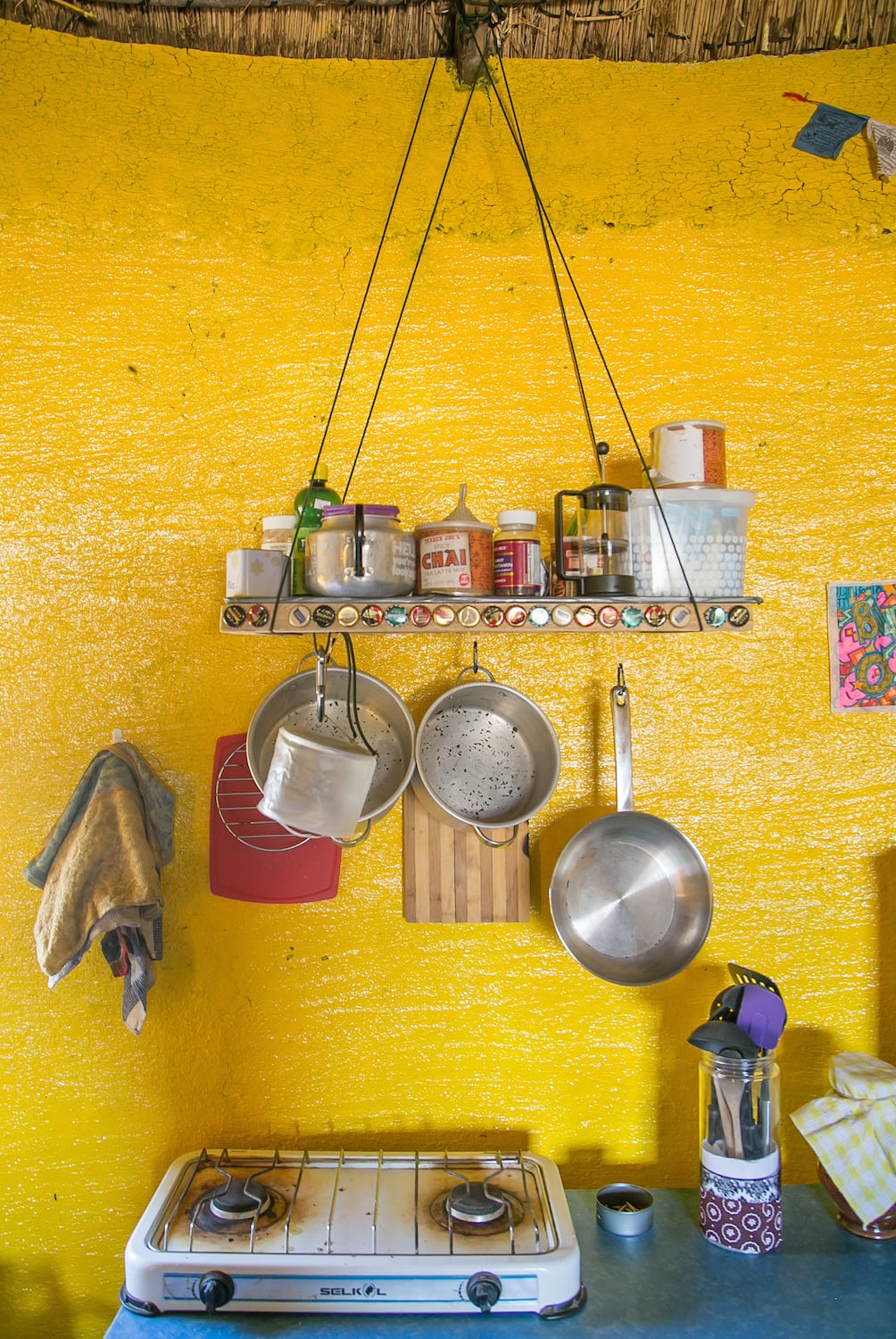 My Pot Rack What I Used: Strong Paracord (brought from the US), small carabiners as hooks, 4 pieces of 2in. x 2in. wood to build the frame, an old mop sawed into four pieces to make the perpendicular rows where things are hung, Mpowered light, flat board to create the shelf, and nails! Cost: $20