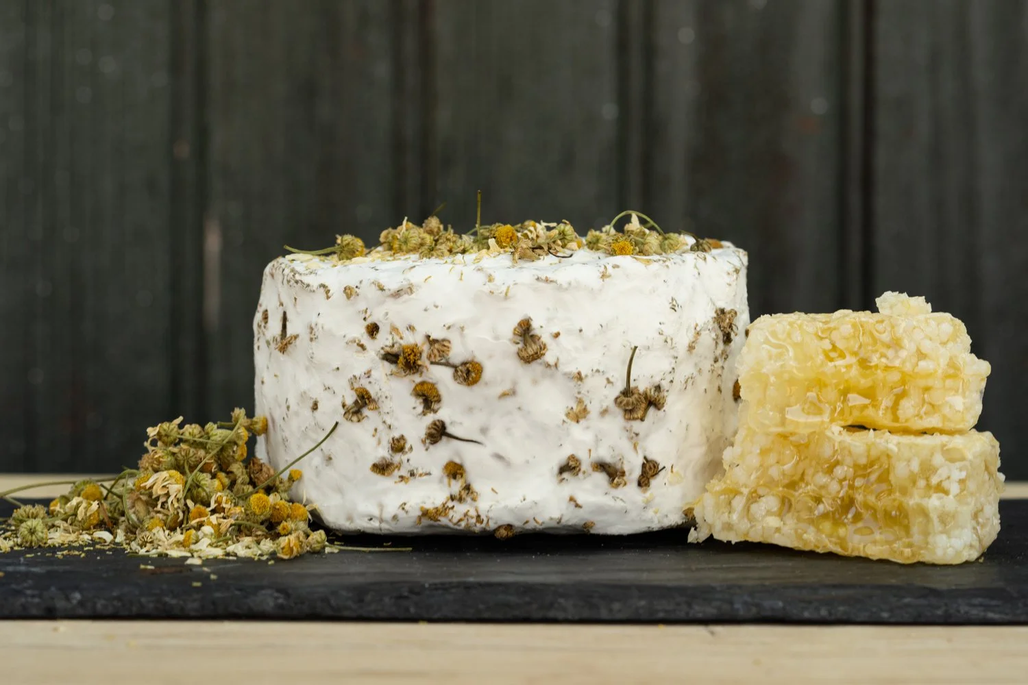 Wheel of Honey Bell cheese coated in dried chamomile flowers, with a cut wedge, Valley Milkhouse CreameryZS_ValleyMilkhouse_108.jpg