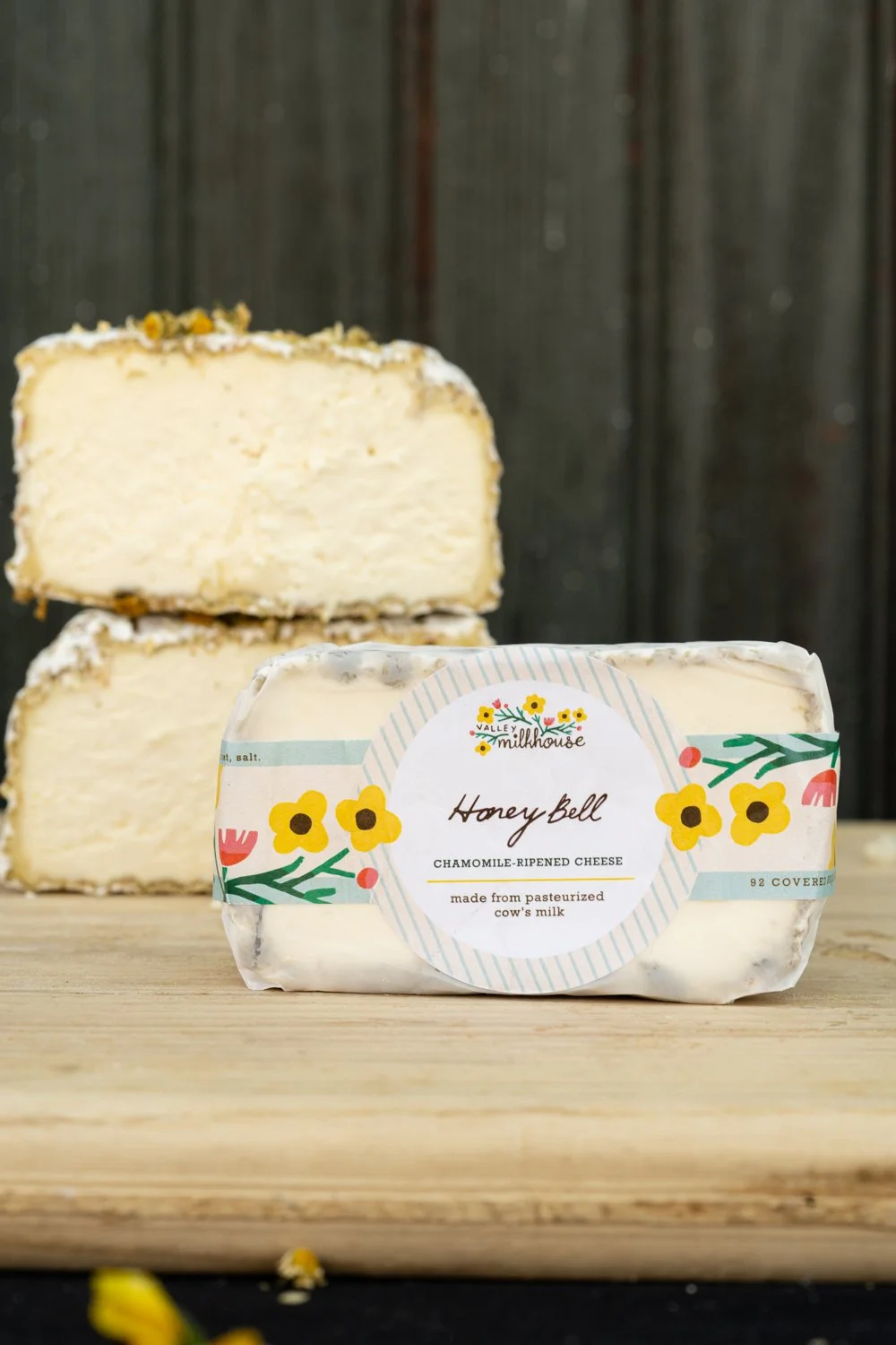 Wedge of Honey Bell cheese wrapped in printed cheese paper with a handwritten label, from Valley Milkhouse CreameryZS_ValleyMilkhouse_110.jpg