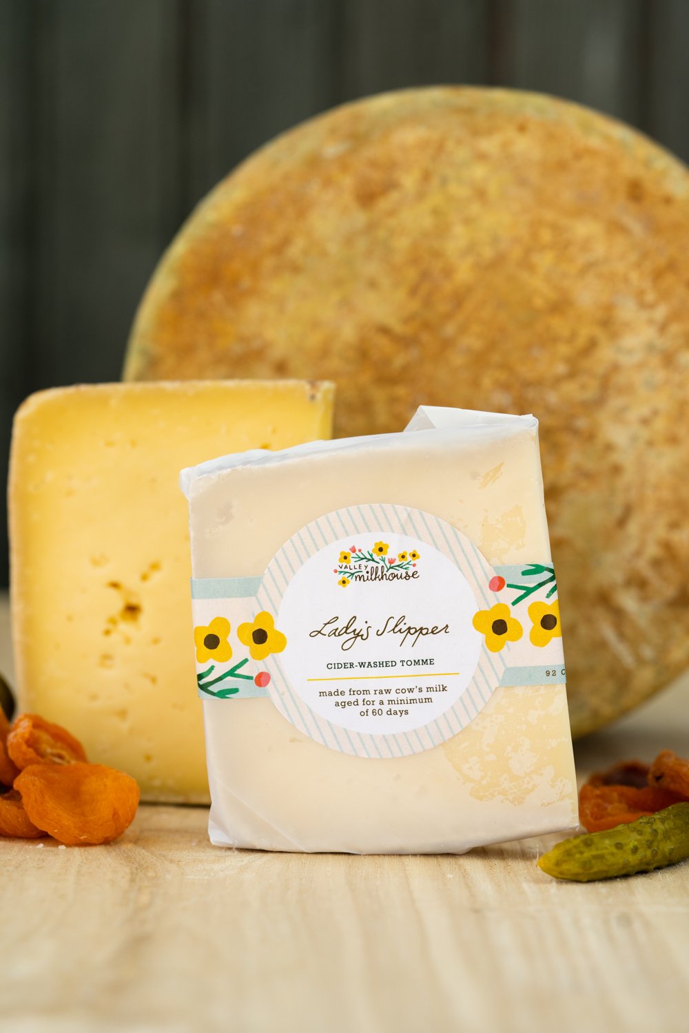 Wedge of Lady's Slipper cheese wrapped in printed cheese paper with a handwritten label, from Valley Milkhouse CreameryZS_ValleyMilkhouse_082.jpg