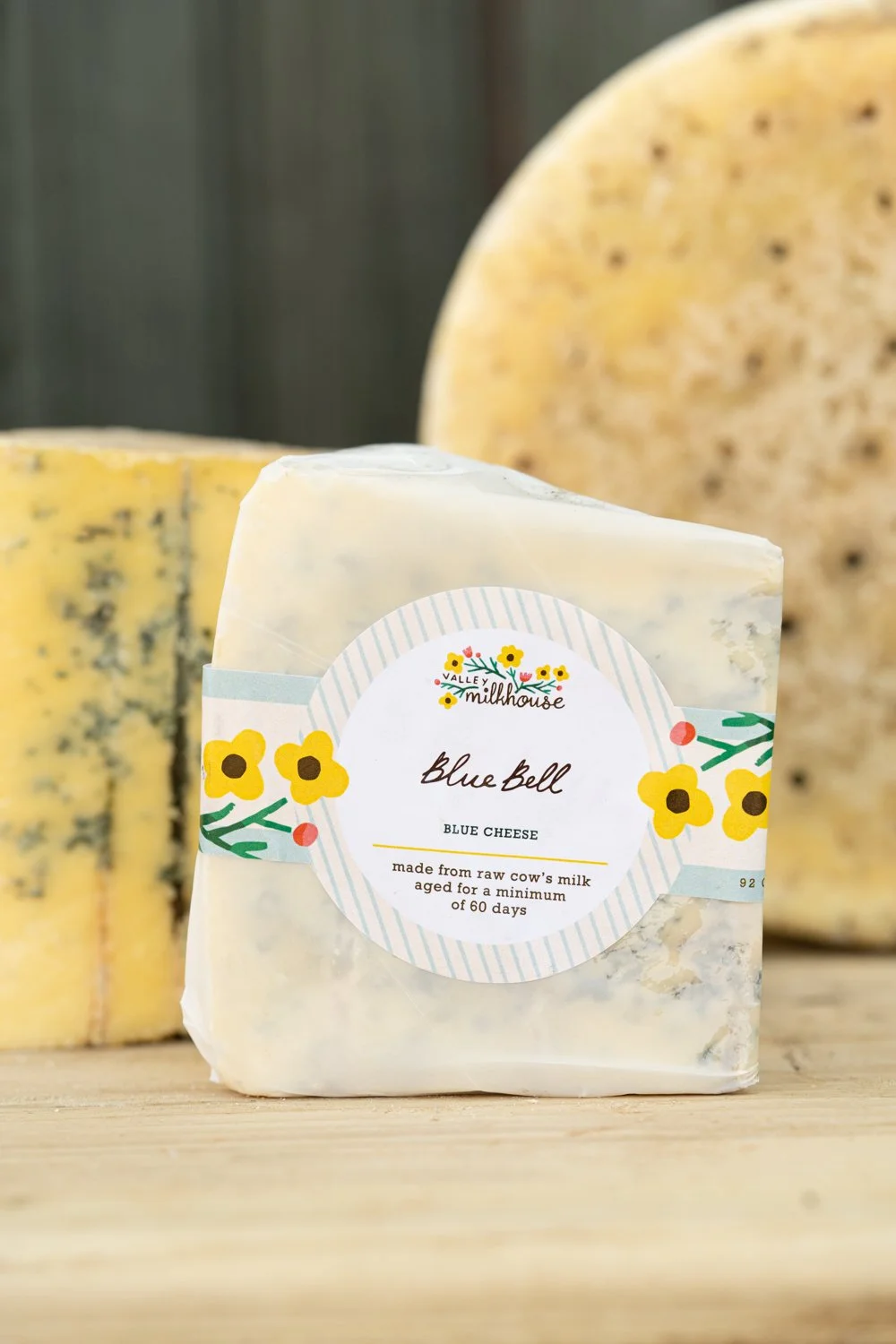Wedge of Blue Bell cheese wrapped in printed cheese paper with a handwritten label, from Valley Milkhouse CreameryZS_ValleyMilkhouse_093.jpg