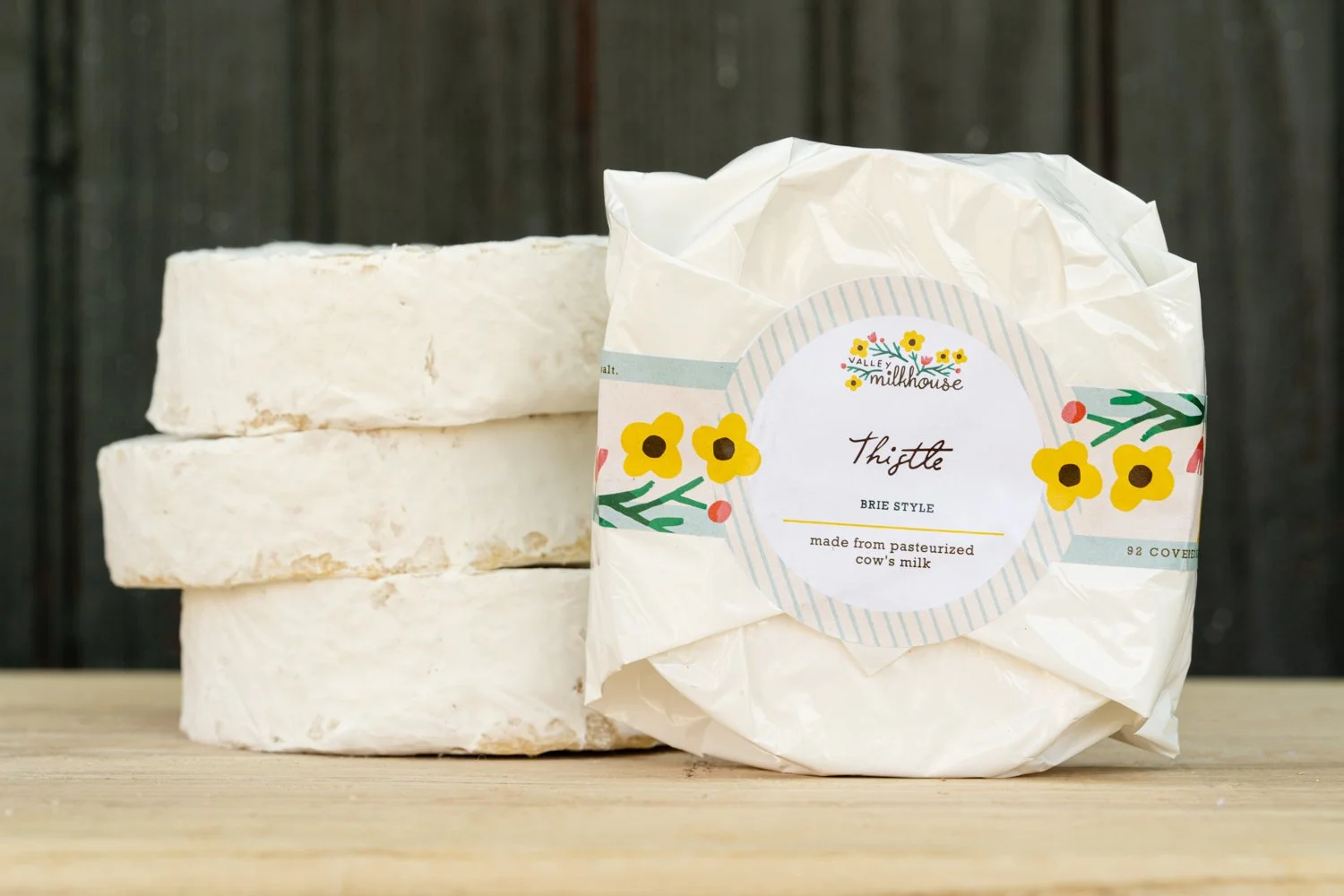 Wheels of Thistle cheese wrapped in printed cheese paper with a handwritten label, from Valley Milkhouse CreameryZS_ValleyMilkhouse_105.jpg