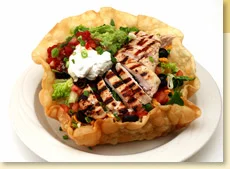 Tortilla bowl filled with chicken & salsa and topped with Mexican Guacamole