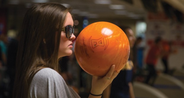 Fresno State student Shaela Warkentin, 19 holds her bowling ball as she gets assistance from Coach Duncan in her bowling class.