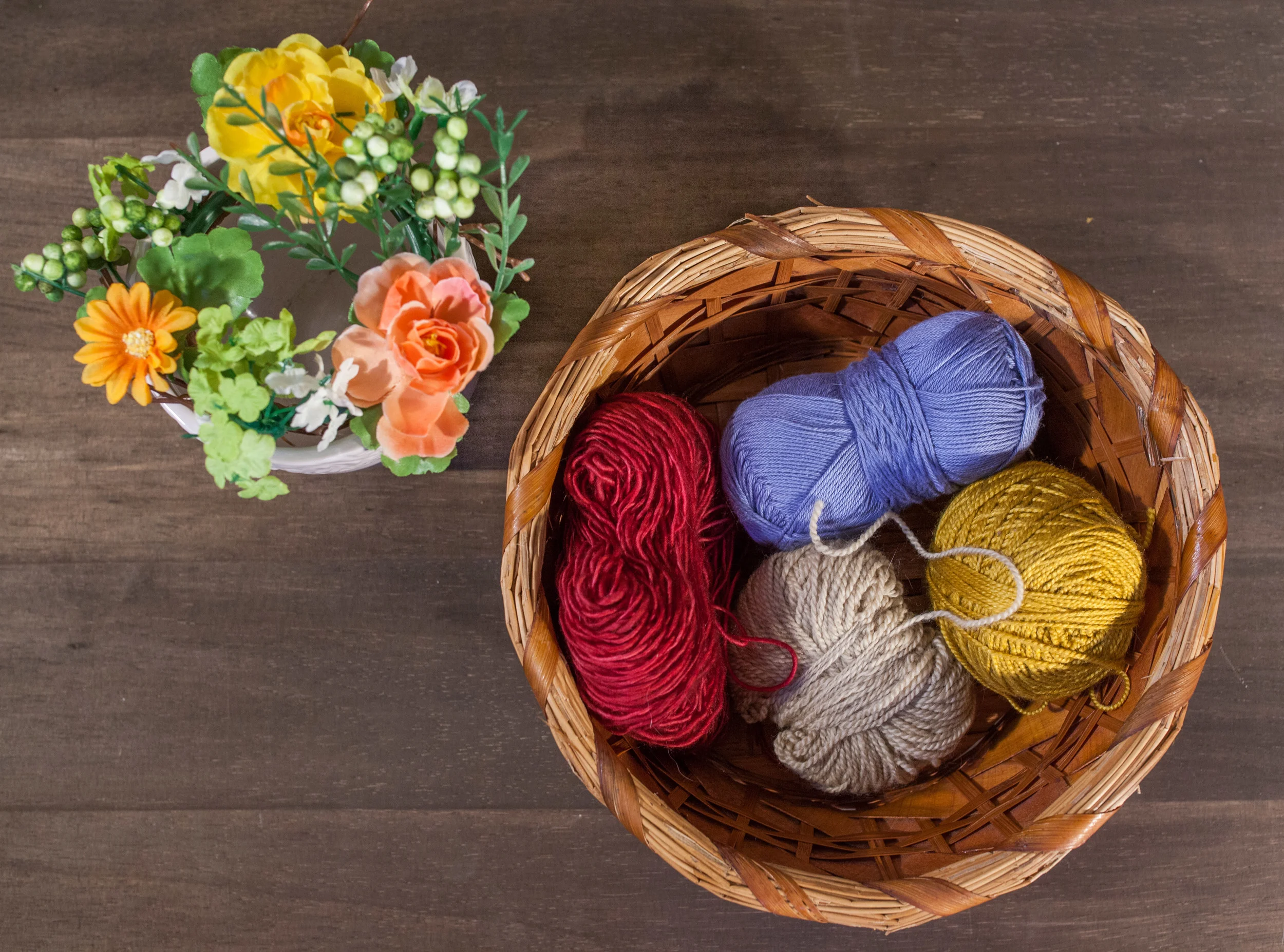 Pictured: flowers and four different types of fingering weight yarn.