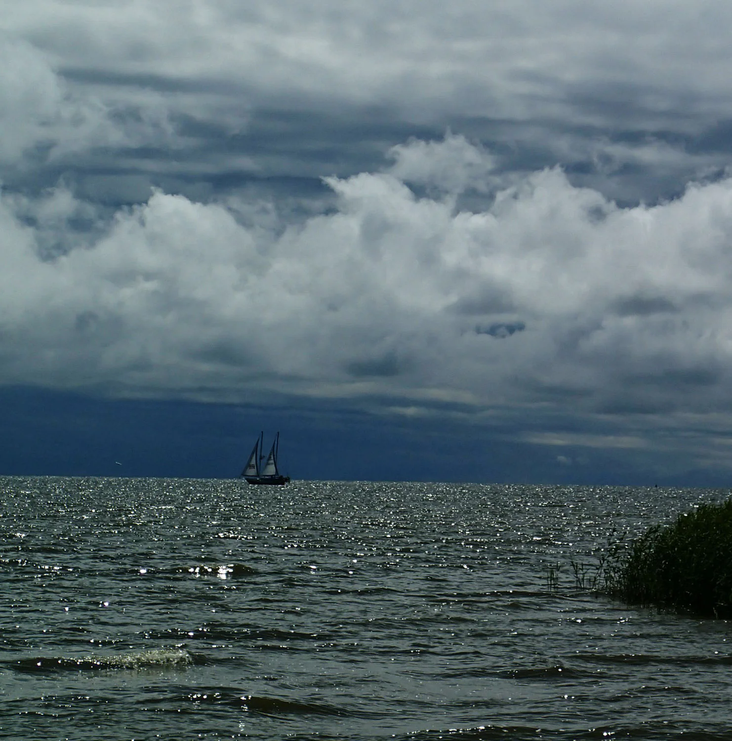 Light dances across the waves as a boat sails across the Baltic Sea in the distance.