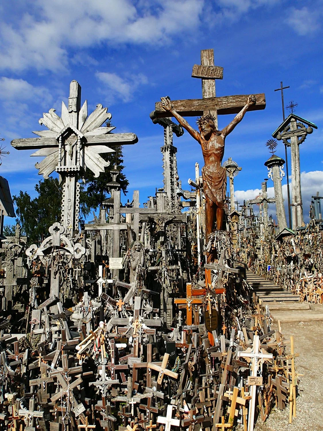 One of Lithuania's most awe-inspiring sights: The Hill of Crosses. The tradition of placing crosses began in the 14th century & likely arose as a symbol of defiance against foreign invaders. During the Soviet era, the pilgrimage to the Hill of Crosses served as a vital expression of Lithuanian nationalism. The Soviets repeatedly removed crosses placed on the hill by Lithuanians even going so far as to level the hill three times covering it in waste & sewage. Following each of these desecrations, local inhabitants & pilgrims from all over Lithuania rapidly replaced the crosses. In 1985, the Hill of Crosses was finally left in peace. The reputation of the sacred hill has since spread all over the world & is visited every year by thousands of pilgrims. 