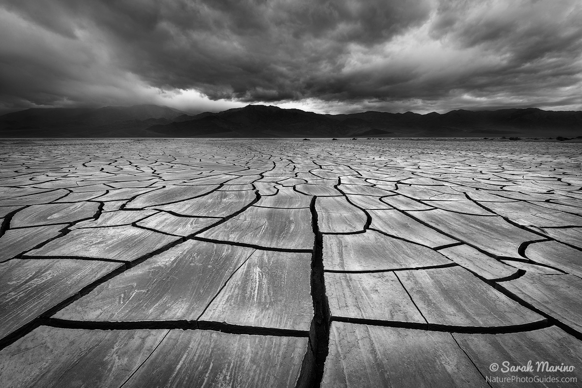 An incoming storm over large mud tiles in Death Valley National Park. 
