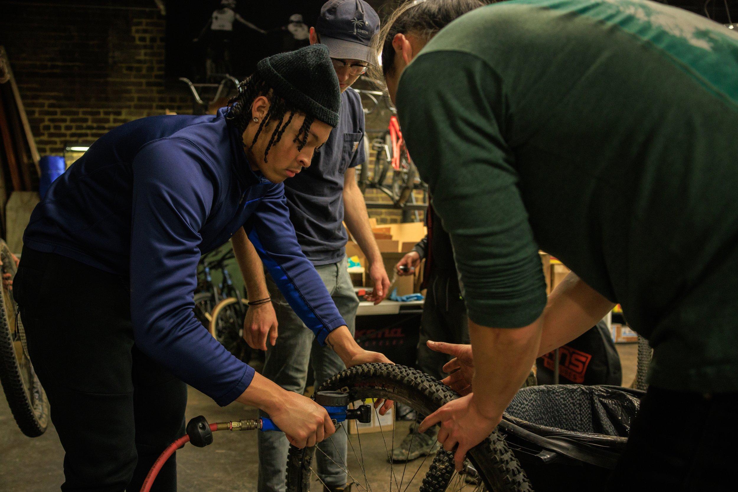 Sam and Wes walk Chris through using the air compressor to seat newly filled tires