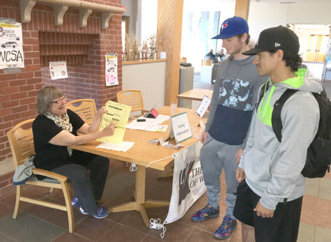 Sara M. Chase/Staff Photo Mary Rehwald of the League of Women Voters/Ashland-Bayfield Counties encourages Northland College freshman Ben Matteson and NC junior Xavier Baez to "Gear Up to Vote," showing them a sample ballot. 