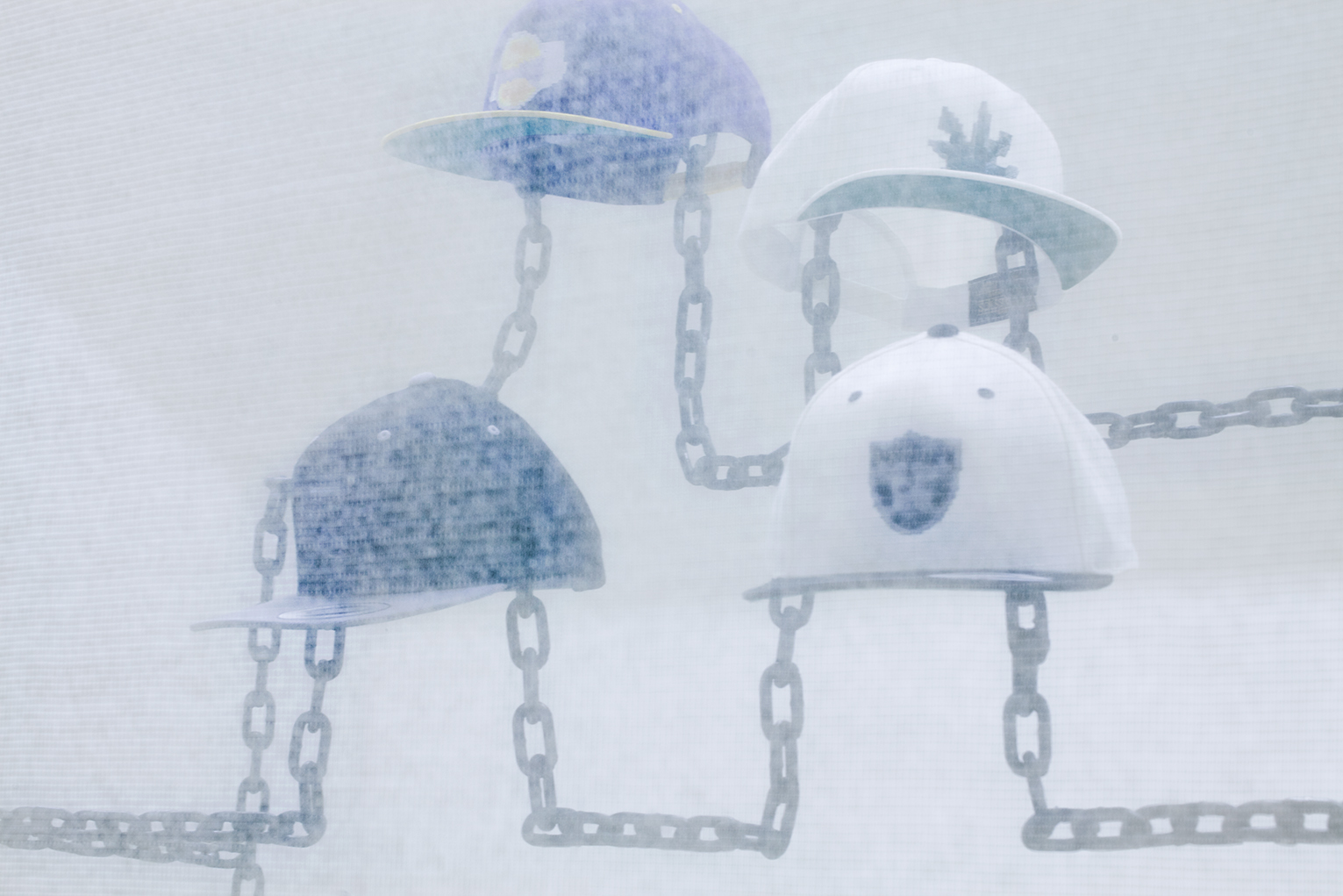 Robin Jiro Margerin Express yourself (Chain gang) 2014 Six digitally blurred logos embroidered on classic snap-back caps, welded steel chain, color inkjet print Courtesy of the artist