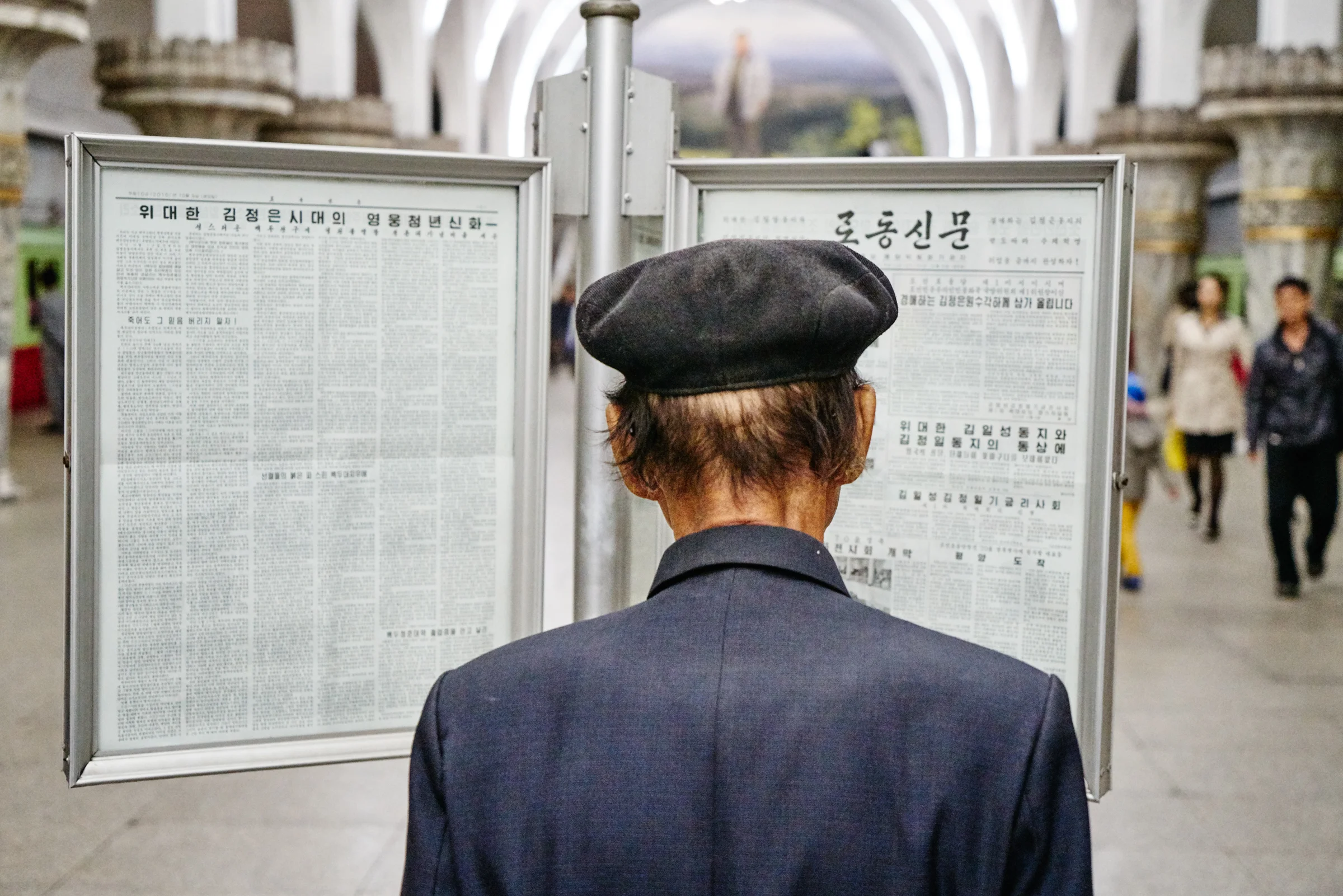 Reading the daily news, Pyongyang metro station. 