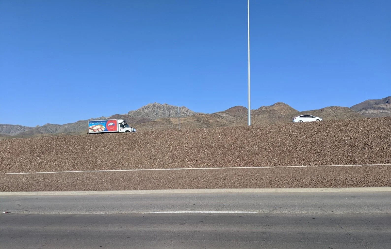 View of mountains near Diana. You see more of the incline of the freeway and passing vehicles.