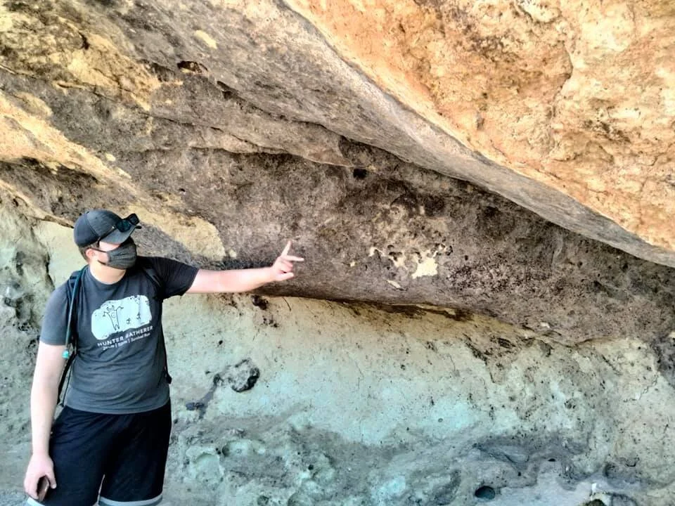 Garrett Leitermann, an archaeologist with BLM, interprets whhat appears in one layer of the rock.