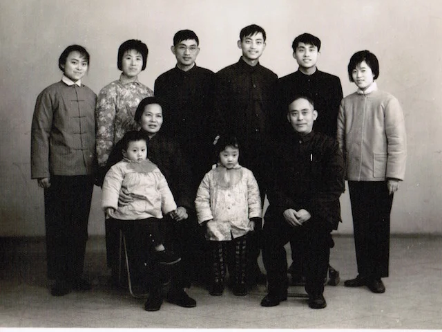 I was four years old, and my brother was three. The back row from left to right: my auntie, my parents, my younger uncle, my older uncle and his newlywed wife. My grandparents sat in the front row. My brother wanted to run away, so my grandma put him on her lap and held his hand. I was the good girl, furtively playing with my coat and exploring my pocket. 