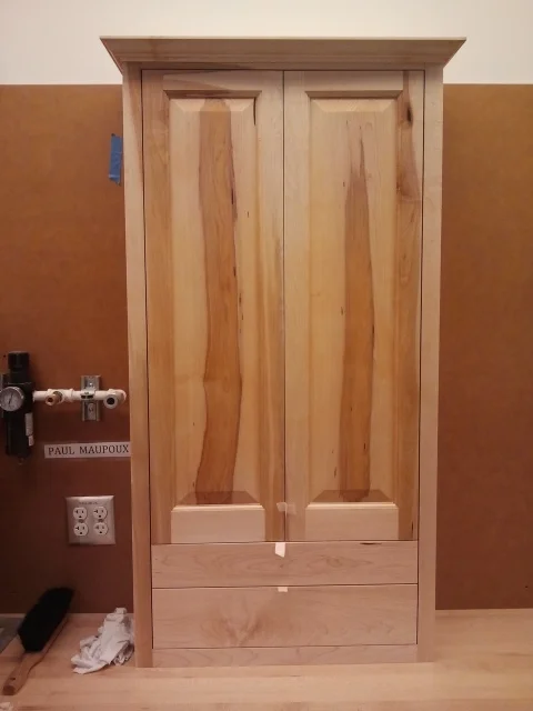  This cabinet is made out of maple and features raised panel doors and crown molding. 