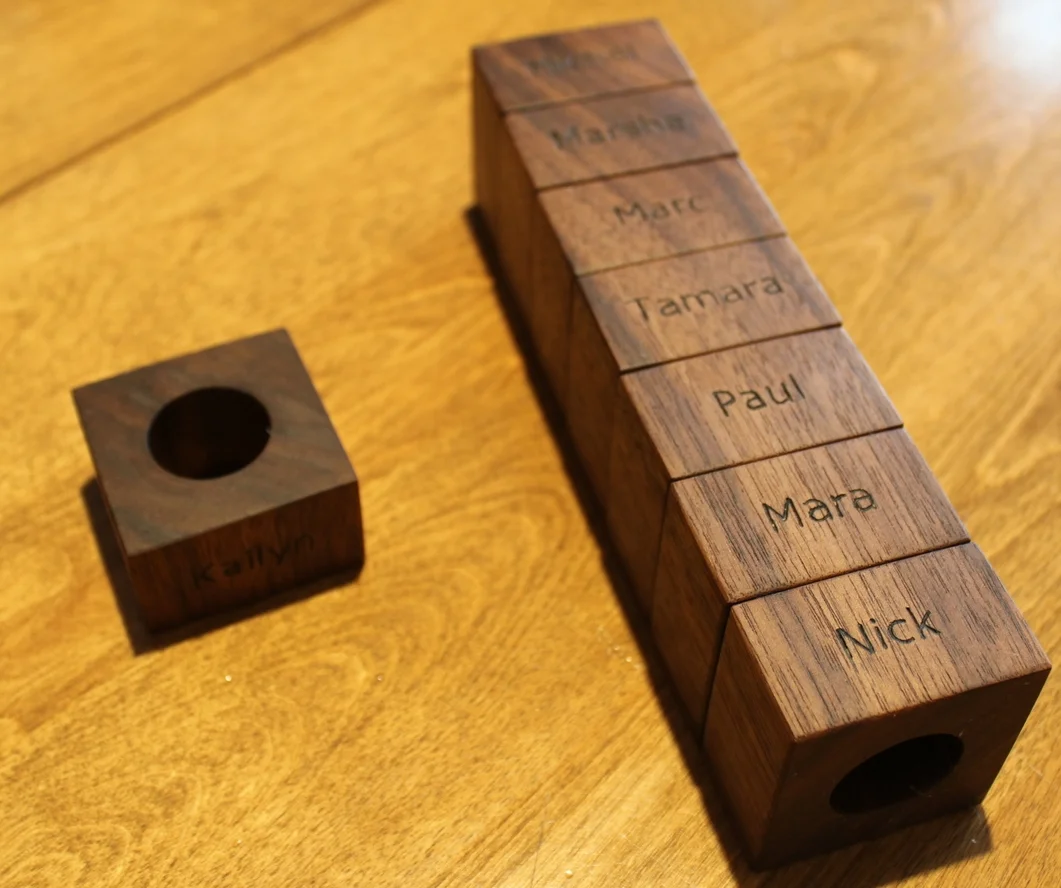   This napkin roll set was made from a continuous length of walnut, such that the grain pattern flows from one ring into the next.&nbsp; The names were engraved by hand with a pyrography tool.  