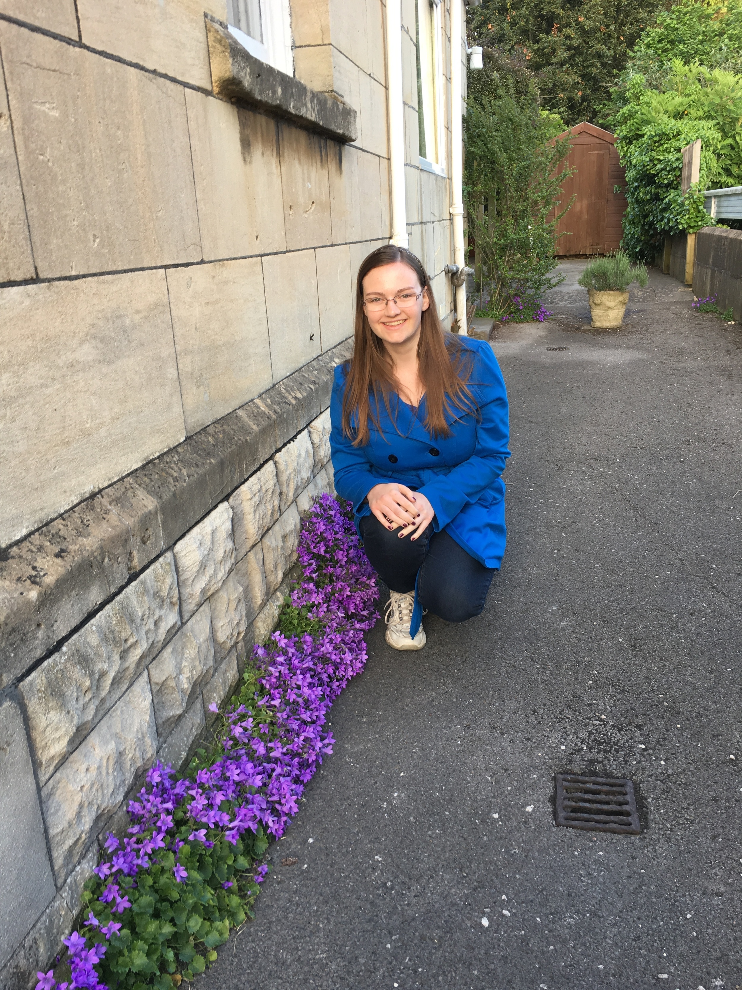  My sister posing with some purple flowers outside of Parkside B&amp;B. 