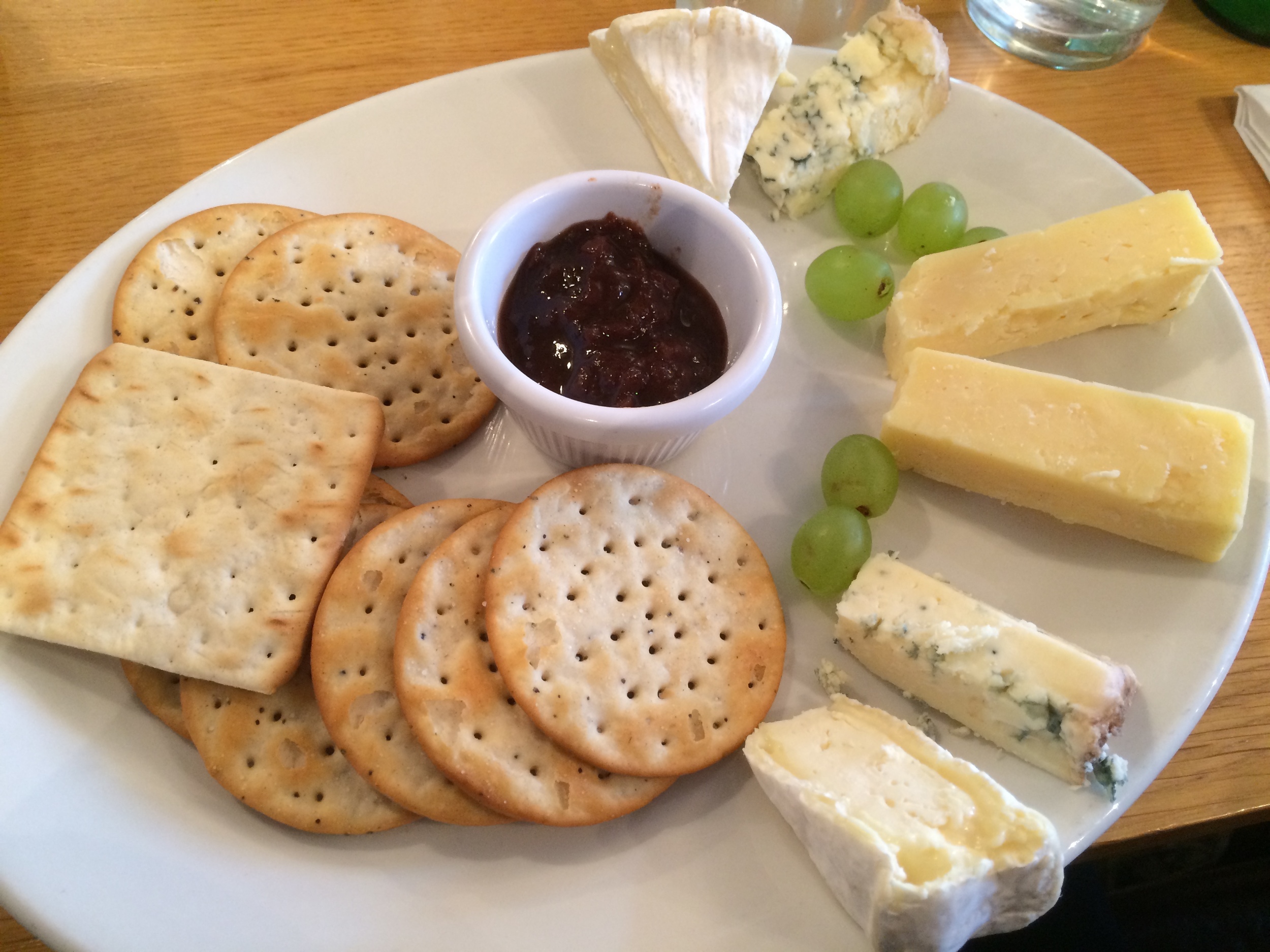  The cheese plate. Cheeses, clockwise from top: brie, blue, white cheddar, blue, and brie. Served with various crackers (left), onion jam (middle) and green grapes. Yes, onion jam sounds weird, but it is amazing and I wish I could find it in the US. 