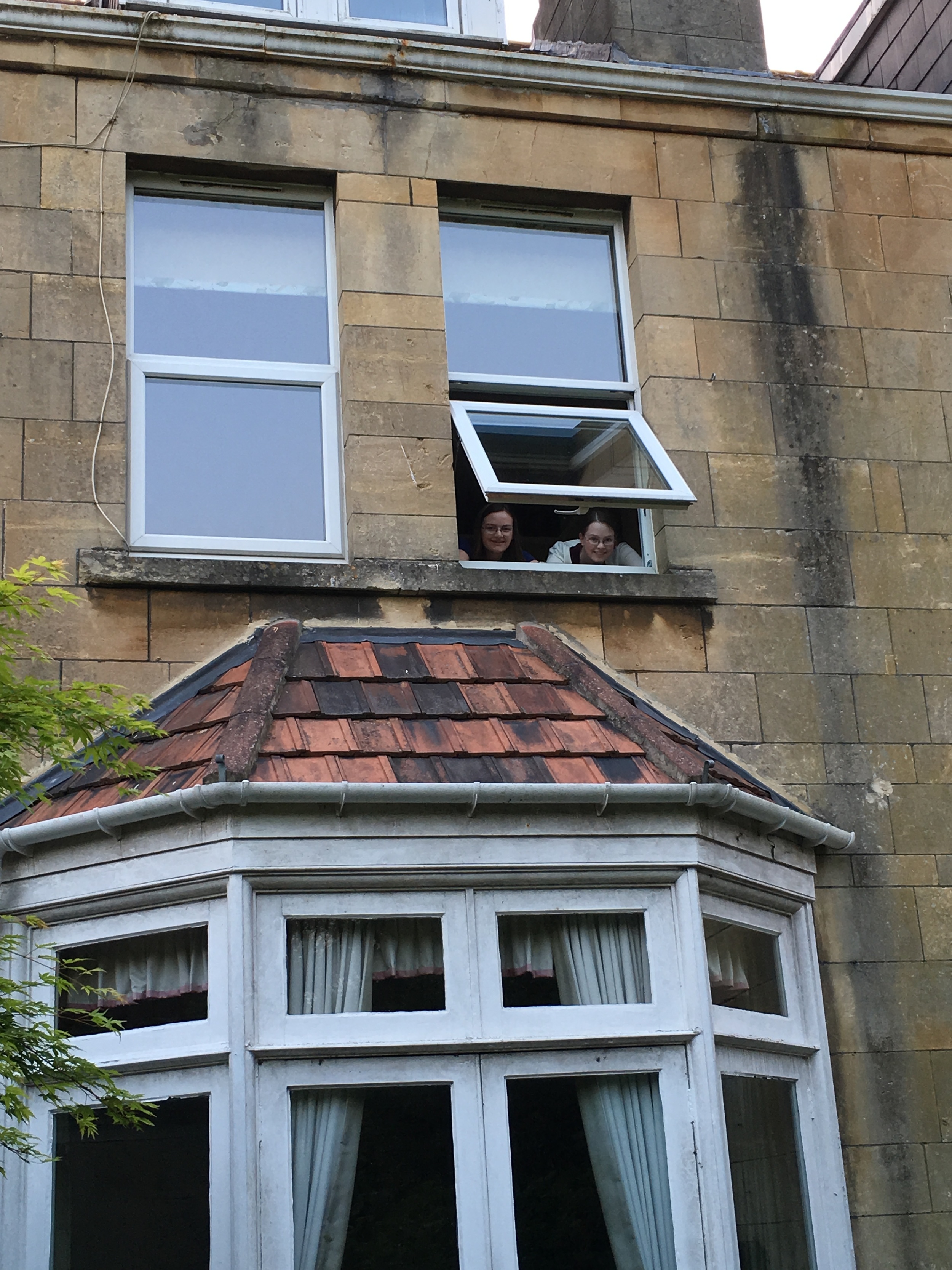  My sister and I peering out of our window. 