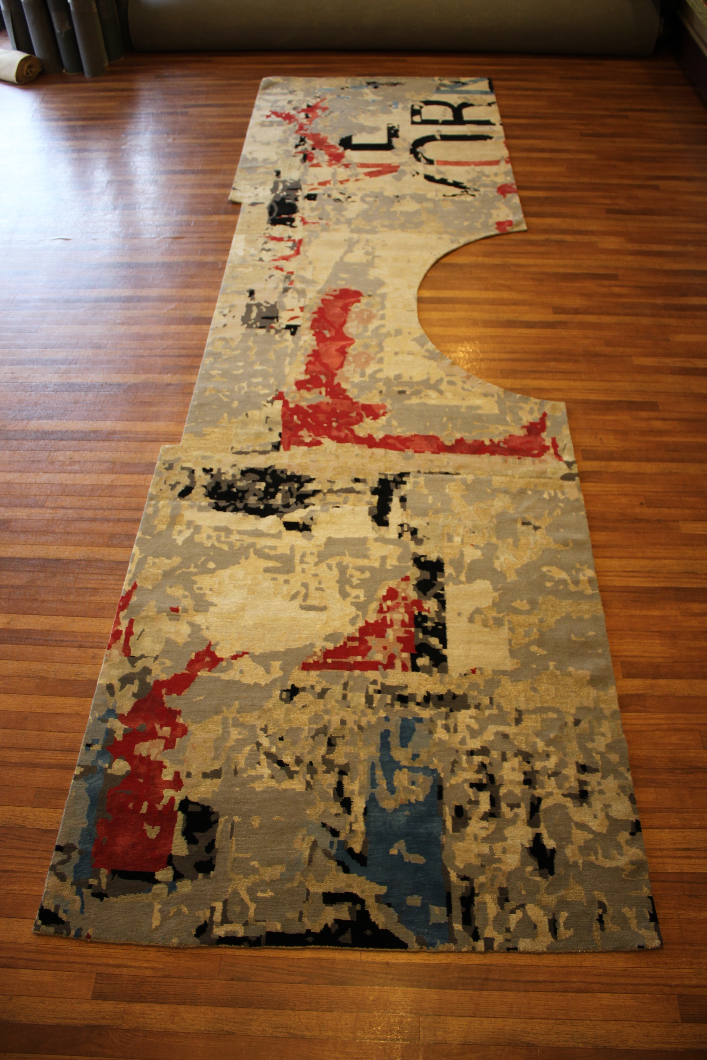 Circular and rectangular cuts made in Tibetan rug to fit around bathroom sink and cabinet.