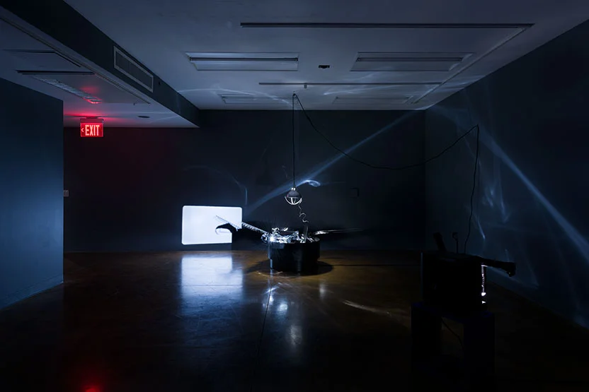 Praxinoscope (2018) (Still view); Kinetic sculpture (motor, wood, metal, mylar sheeting) lamp, 16mm projector; Dimensions variable, installation approximately 90” x 90” x 90”
