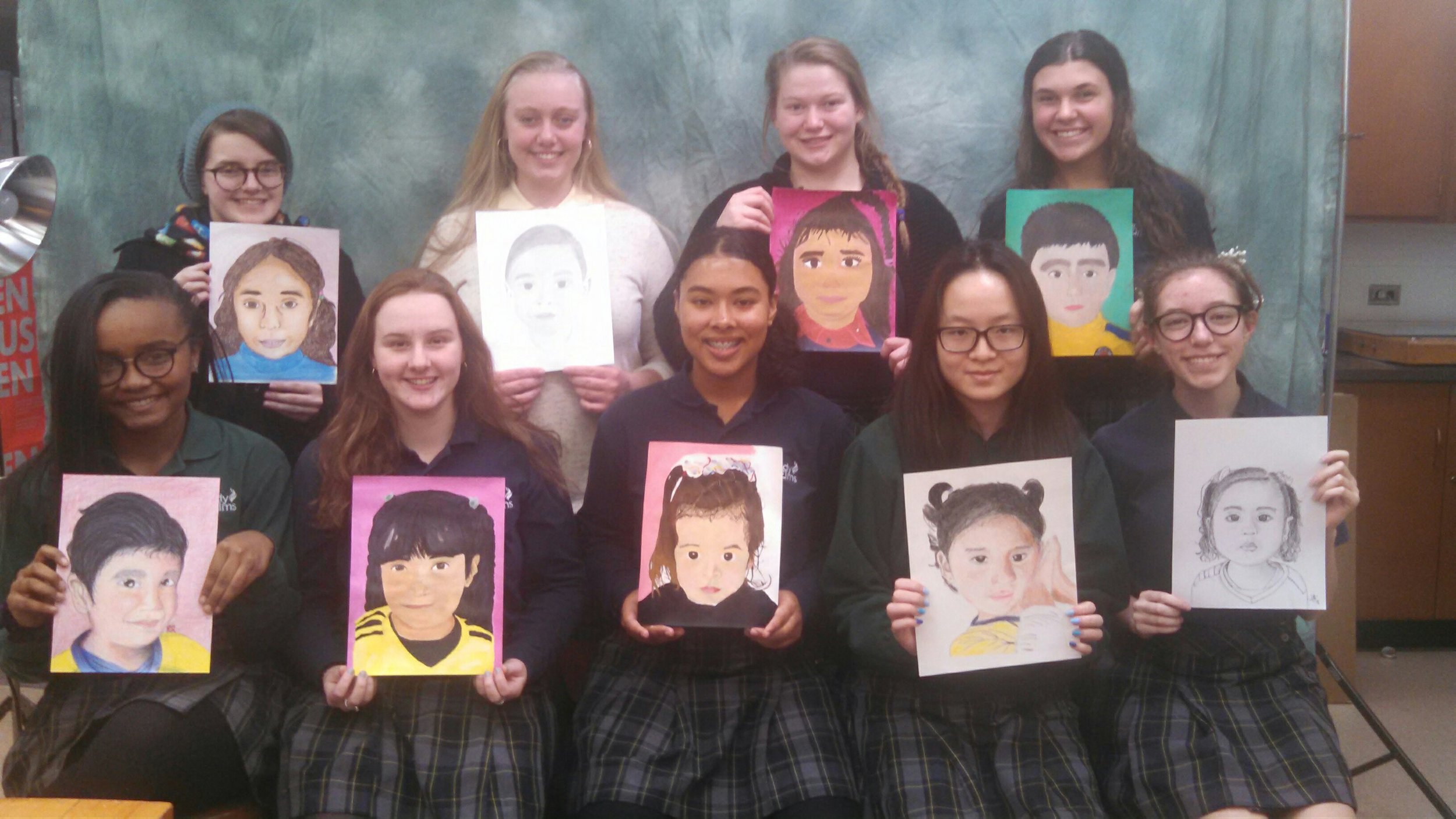 Students display their works of art for the Memory Project.
