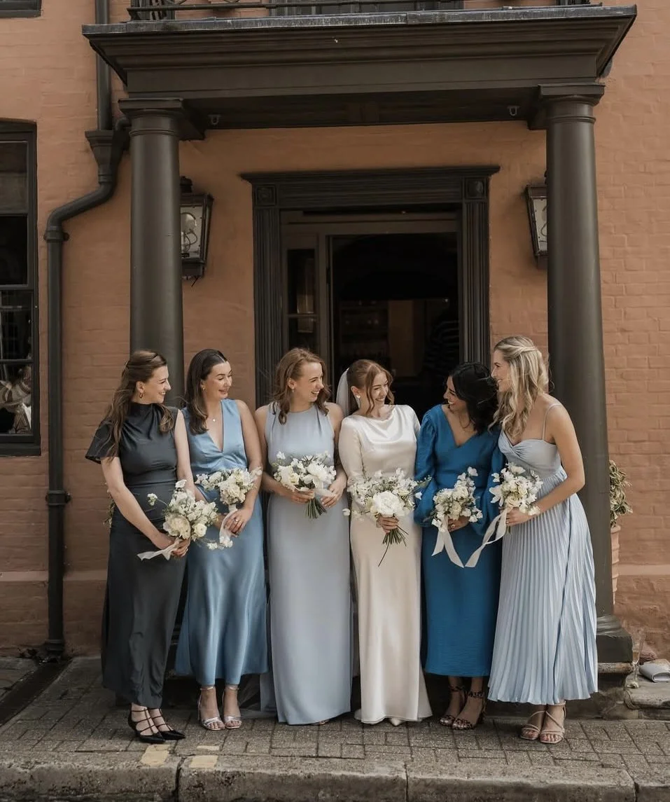 A bride and her bridesmaids lined up for photographs with their bouquets outside the George Hotel in Rye