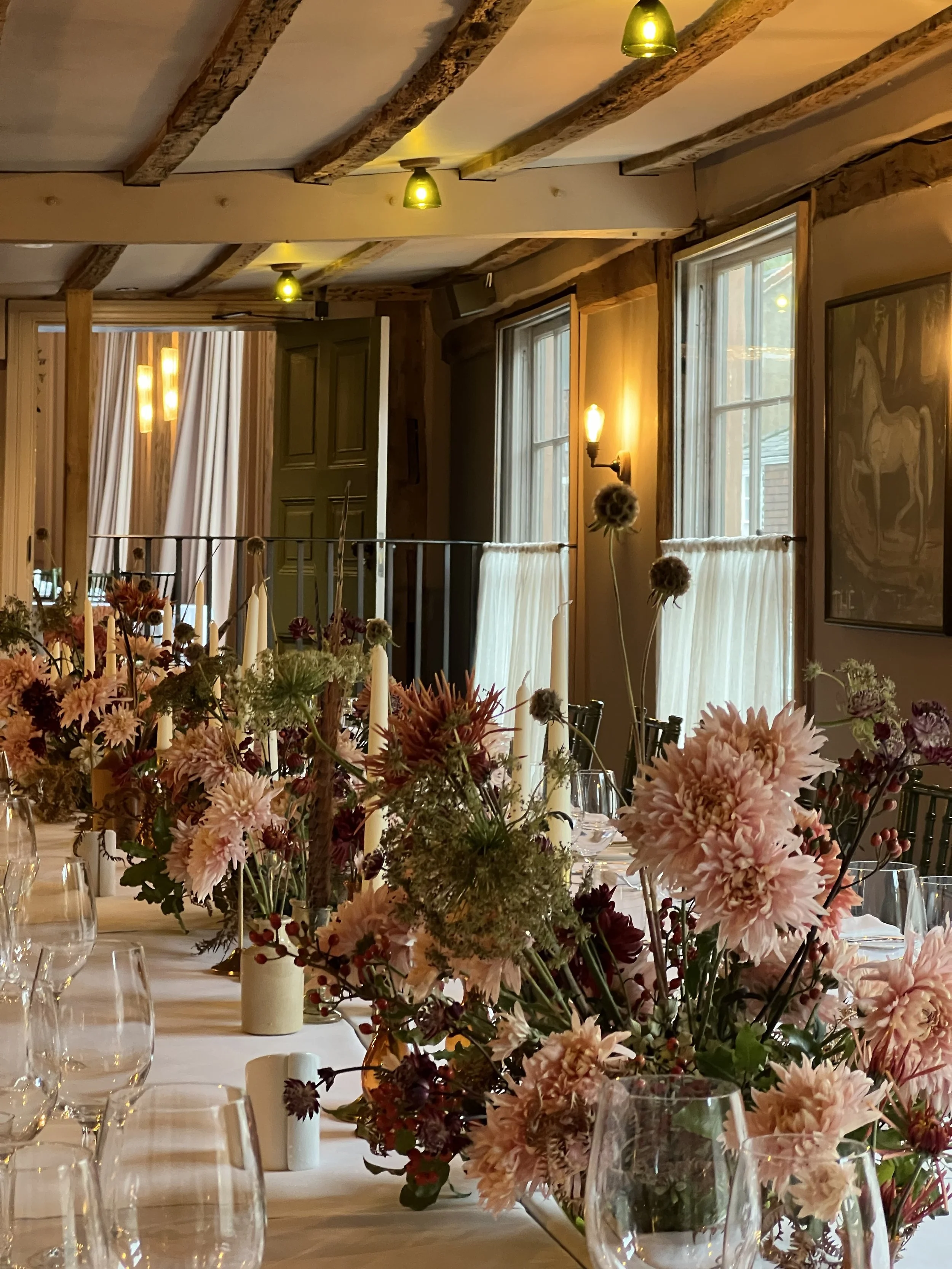 this image shows a beautiful autumnal floral display of chrysanthamums and seed heads for a small wedding at in the Long Room at the George in Rye