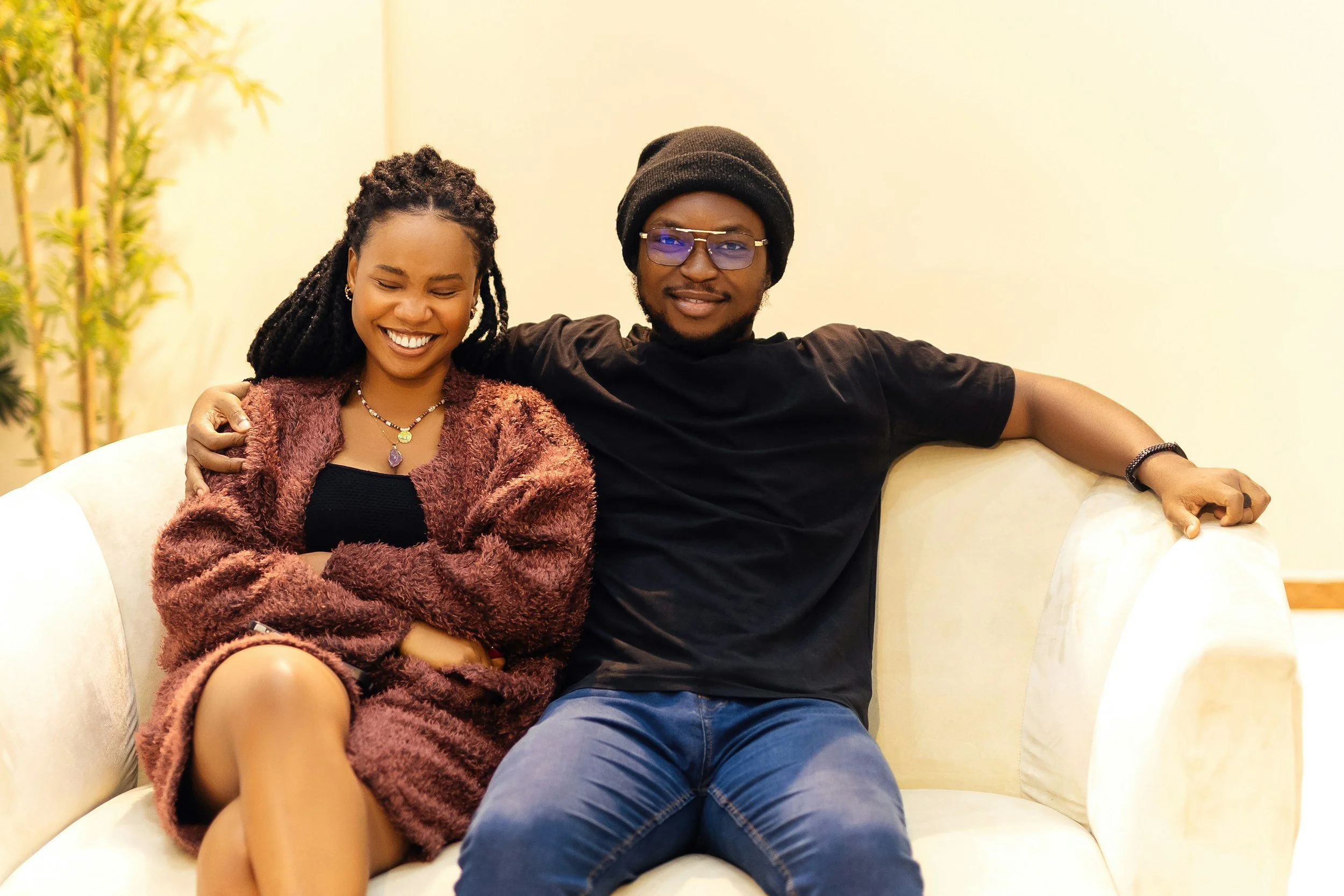 Modern wooden house overlooking a lake with mountain range in the background during sunset.