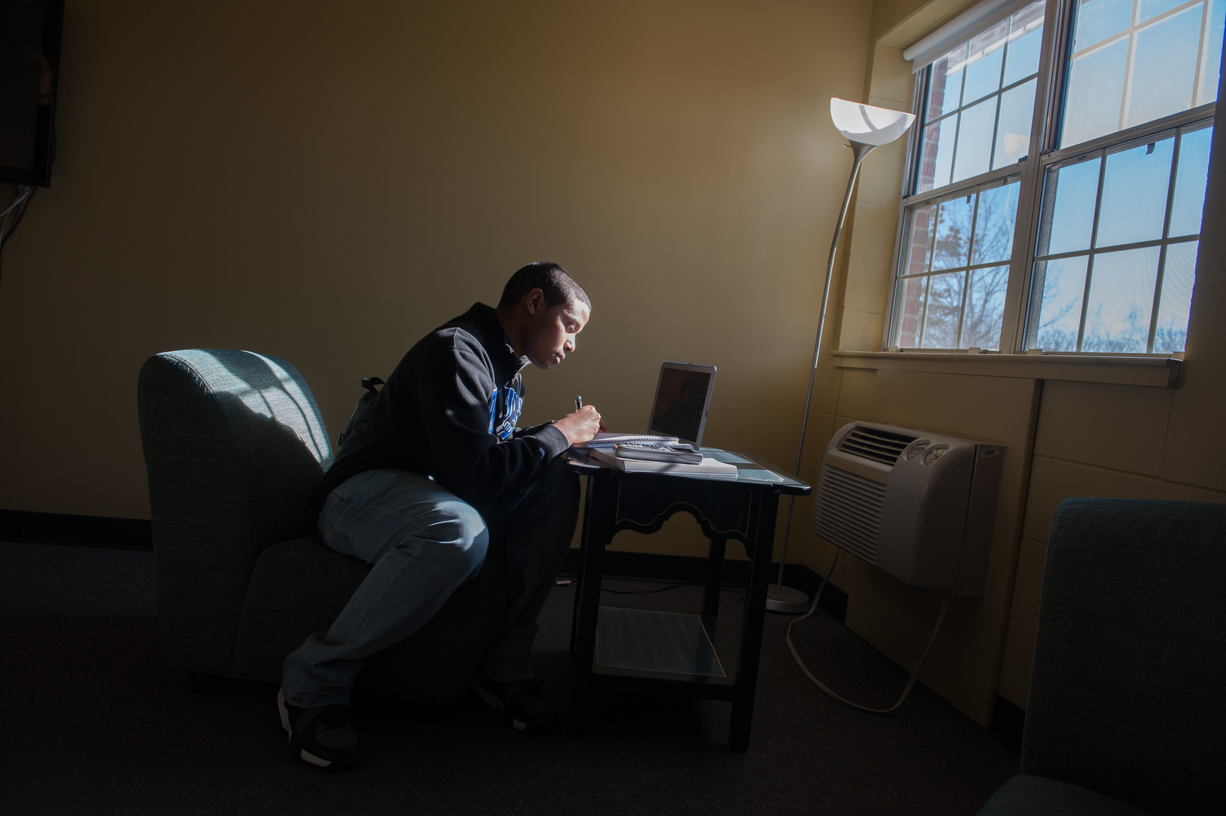 Deyven, the first patient to live on a college campus with a ventricular assist device (VAD) , studies in his dorm's common room.