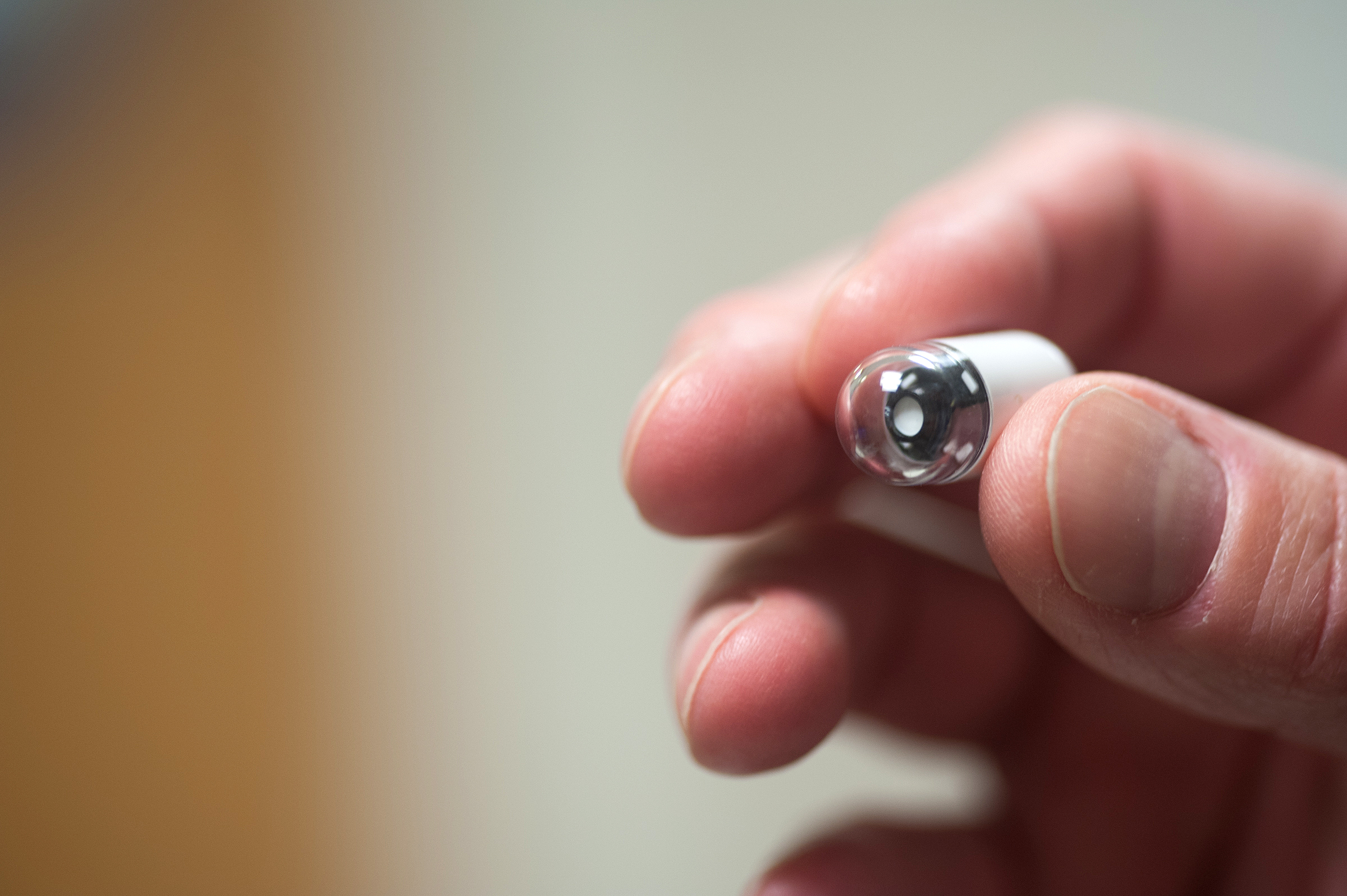 A gastroenterology doctor holds an endoscopy capsule used to record a patient's digestive tract.