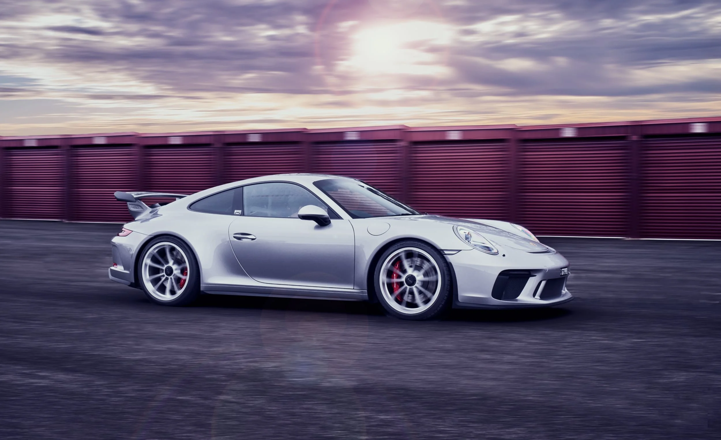 This is a picture of a Porsche 911 GT3 driving near a race track in Melbourne