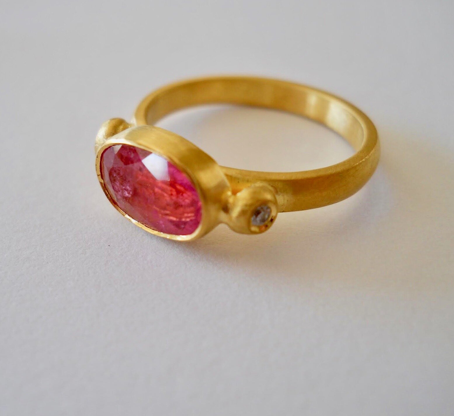 Vibrant Pink Tourmaline 22kt gold ring with diamond accents.