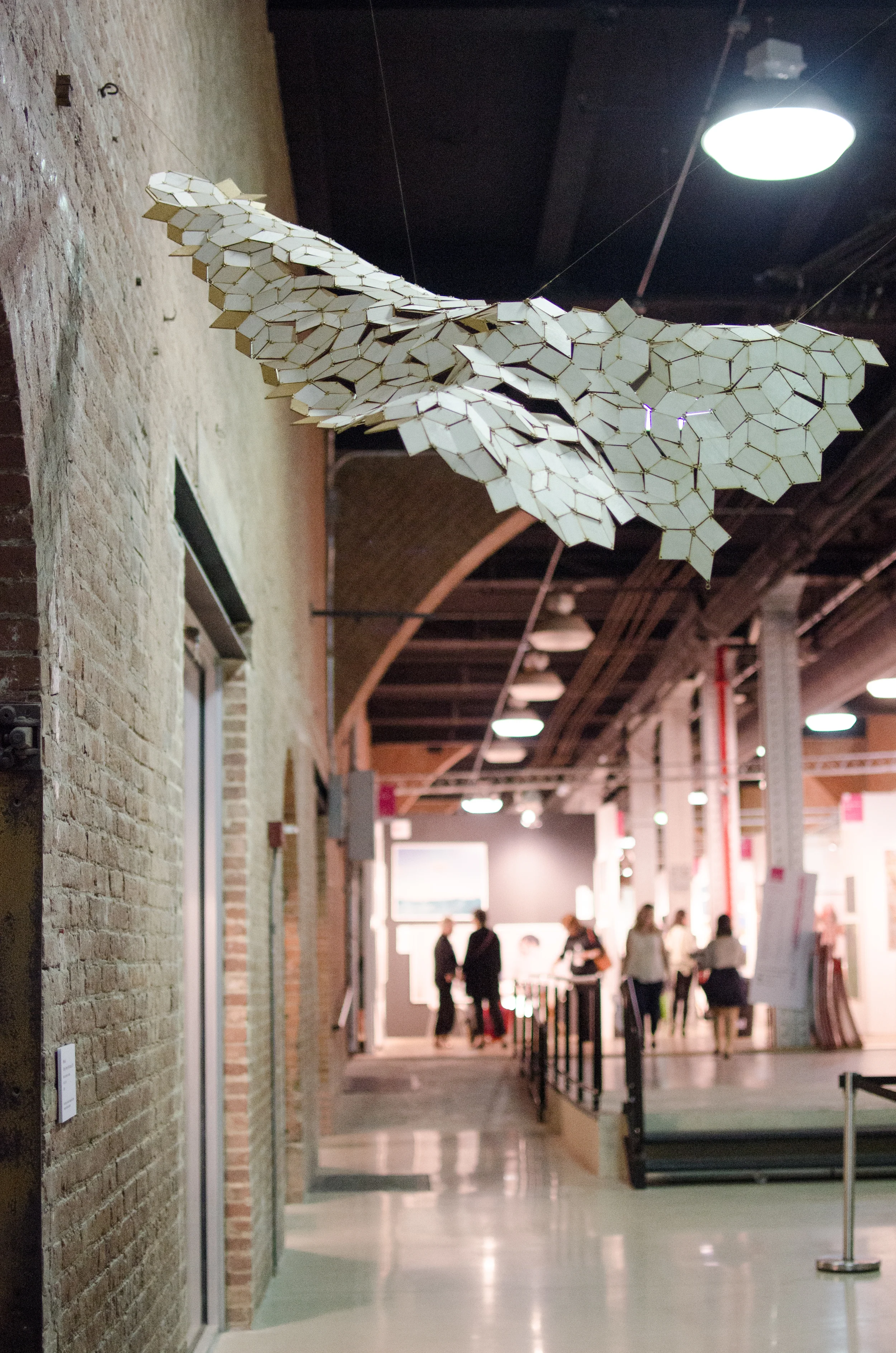 Floating Penrose Rhombuses at the Affordable Art Fair, September 2014. The gold tiles at the right and left edges of the piece highlight the locations that the tiling loses its mirror symmetry. Photo: Talya Stein