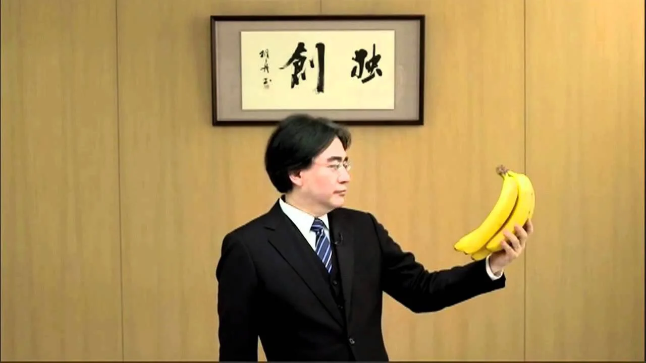 Iwata looking at bananas in a funny skit promoting a Donkey Kong game