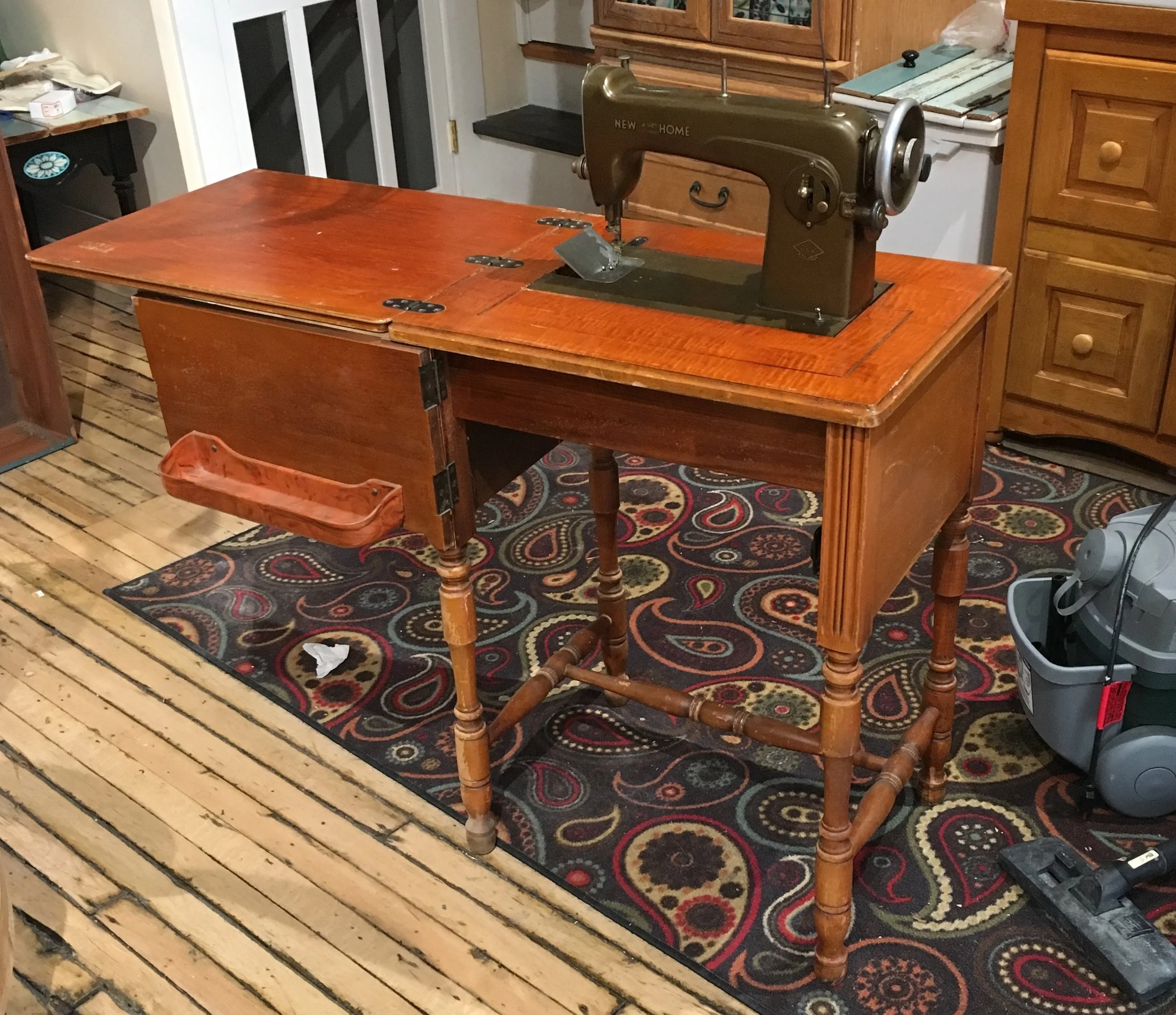 The sink vanity in its former life (and we did find a home for that sewing machine:)