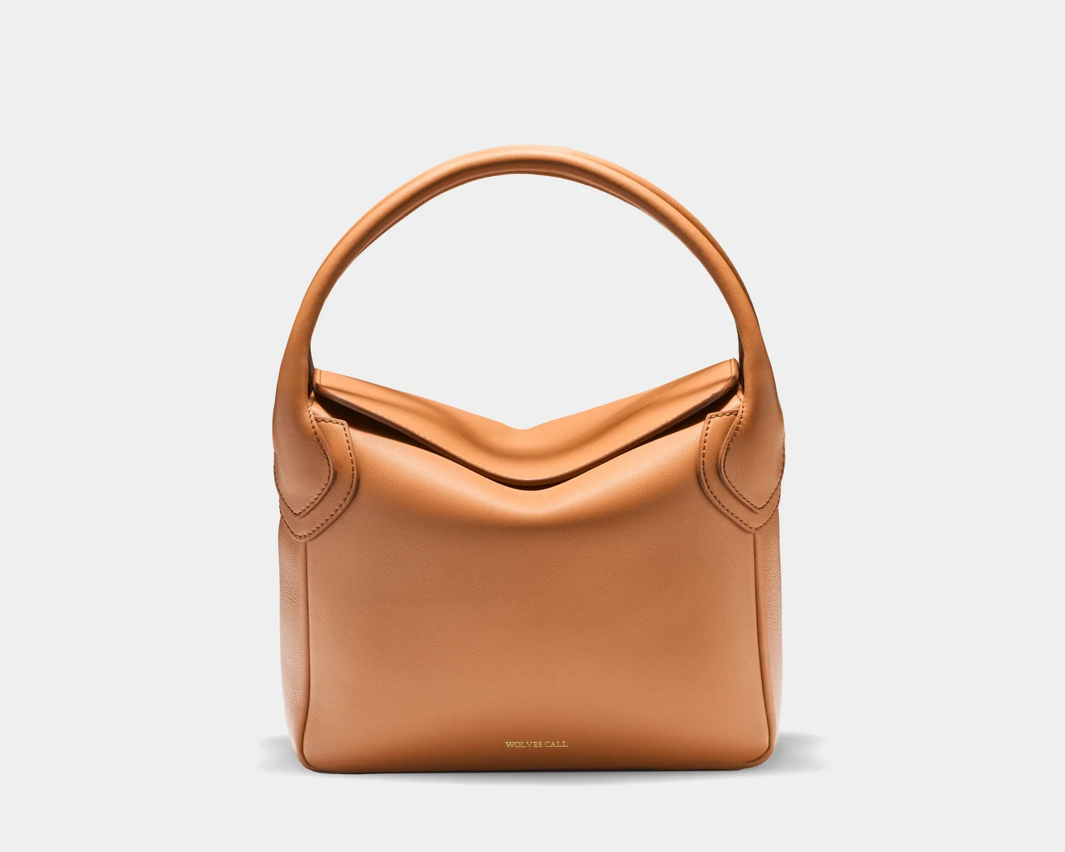 White background product photography of a luxury Wolves Call handbag with natural shadow