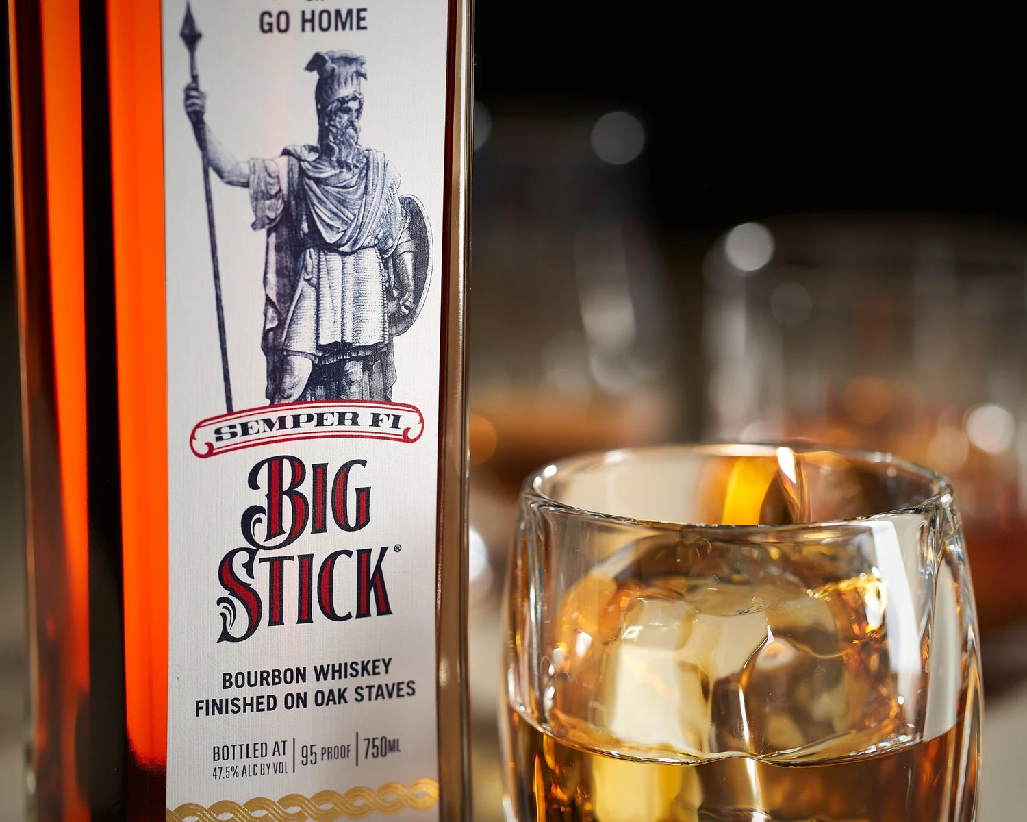 Styled campaign hero shot of Big Stick bourbon with a poured glass