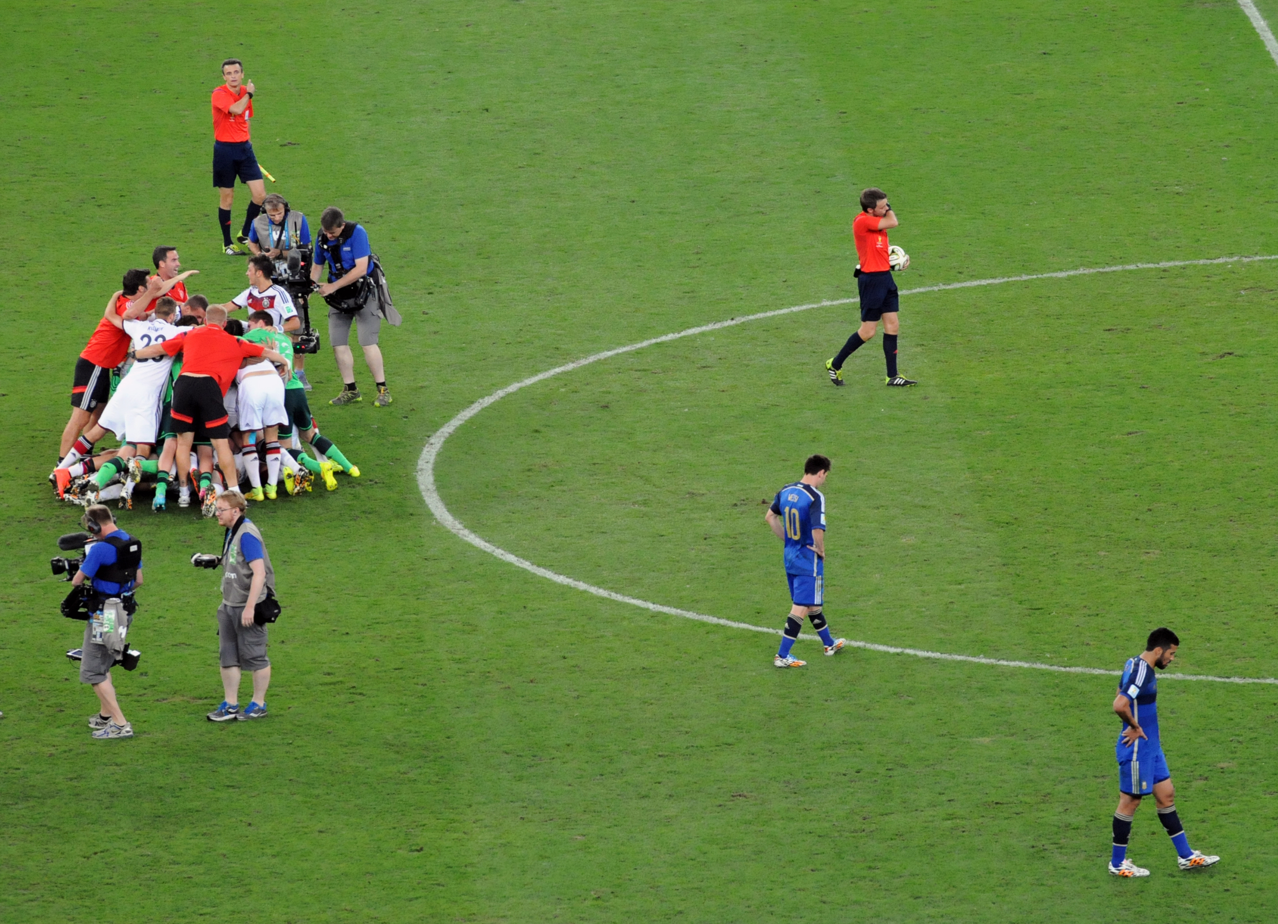 El árbitro italiano Nicola Rizzoli ya pitó el final. Alemania se consagra Campeón del Mundo por cuarta vez en su historia al vencer a Argentina por 1-0 en el Estadio Maracanã de Río de Janeiro el 13 de julio de 2014. Los jugadores alemanes celebran mientras los argentinos Messi y Garay sufren la derrota. Foto: Eduardo Biscayart.